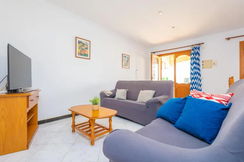 A living room with seating, a coffee table, and a television.