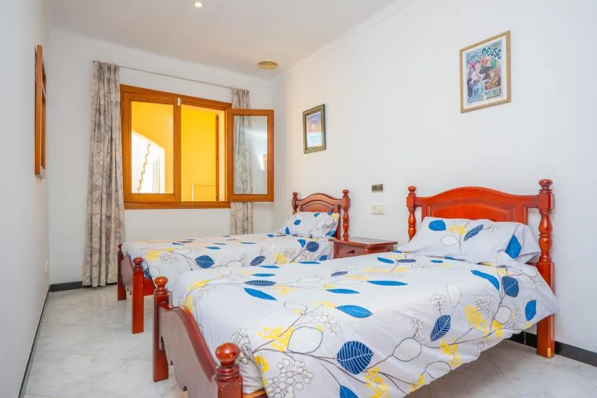 A bedroom with two beds covered in blue-and-white patterned bedding.