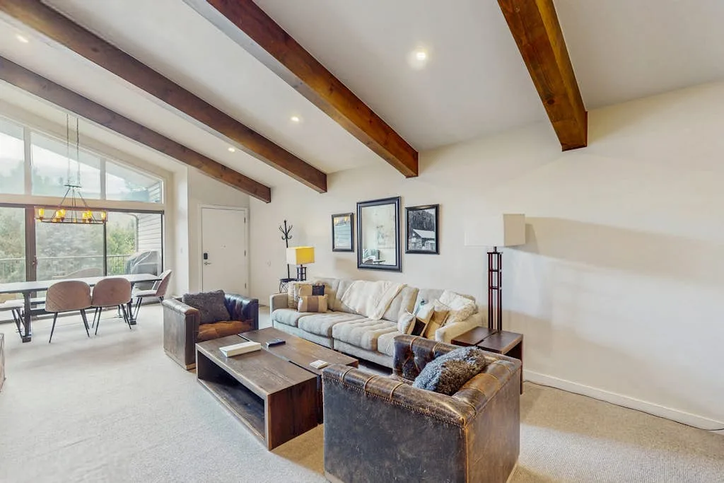 A bright living room with seating, coffee tables, and large windows.