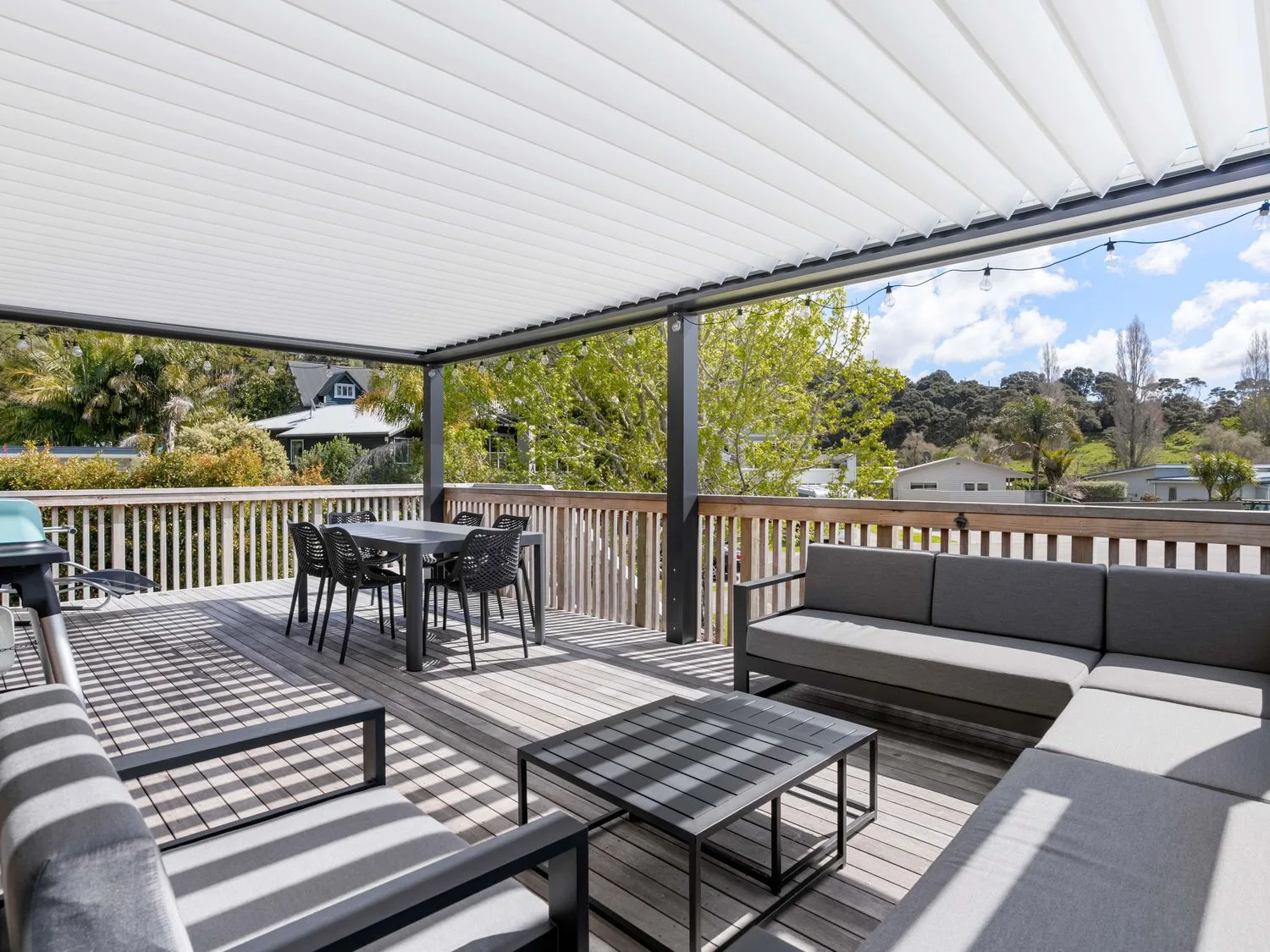 An outdoor area with seating and a table at The Cove Escape - Cooks Beach