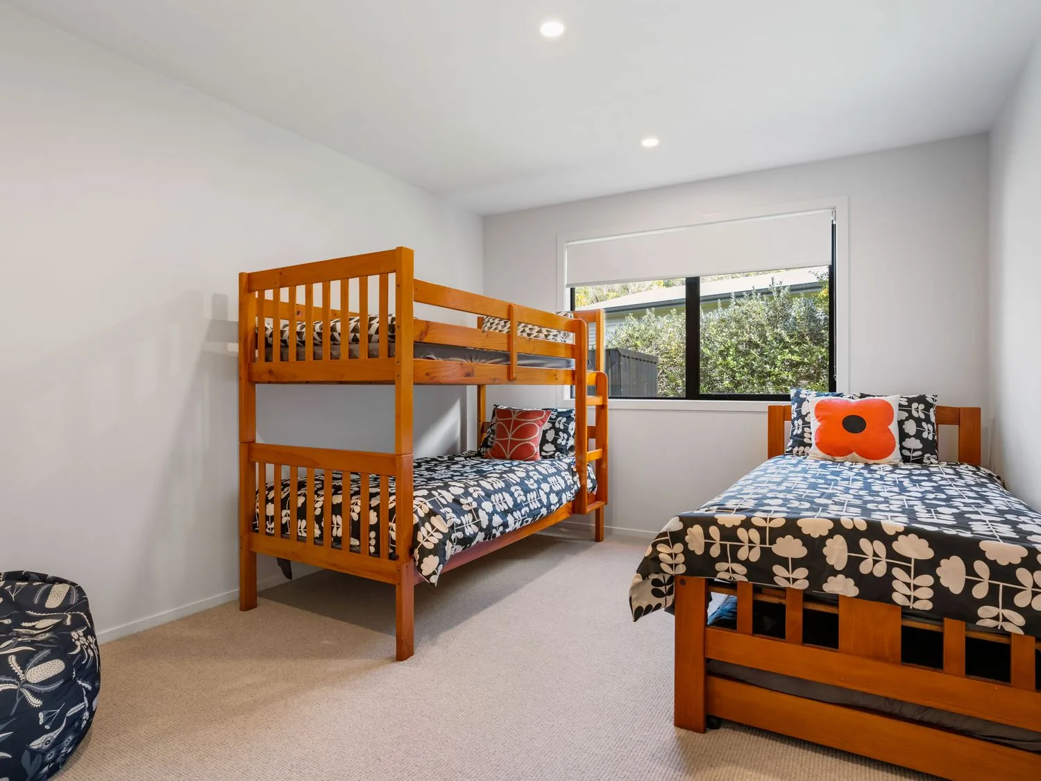 A bedroom with a bunk bed and a single bed at The Cove Escape - Cooks Beach