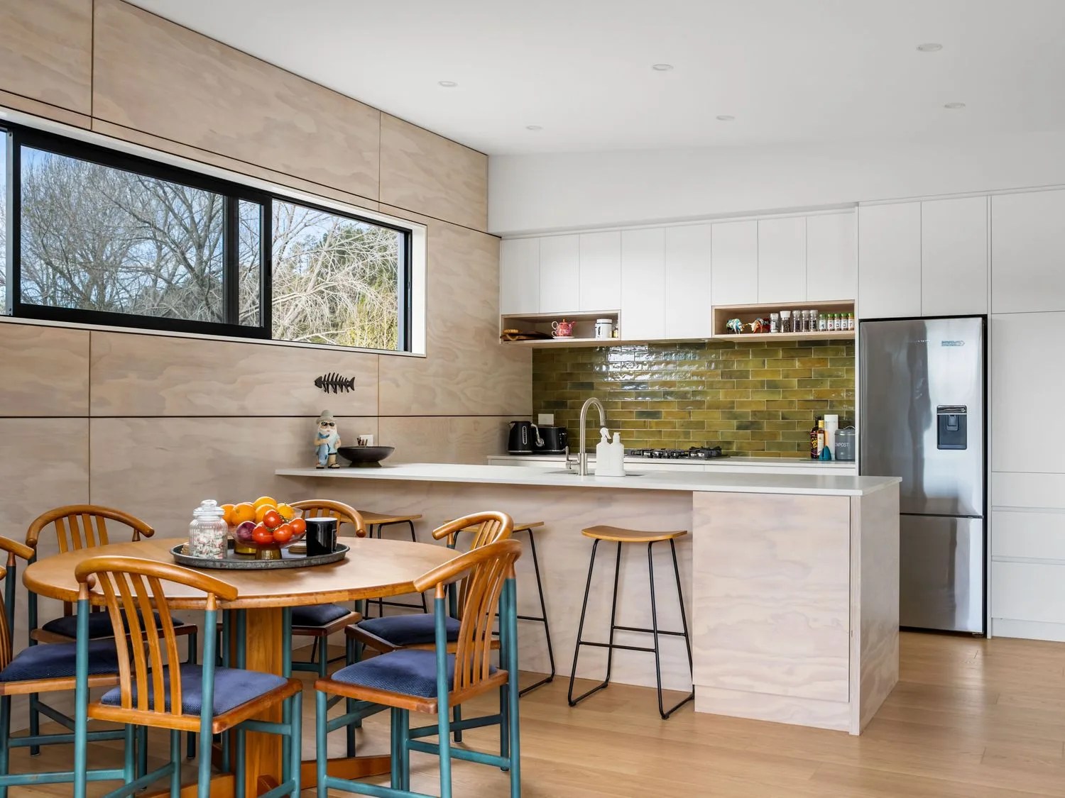 A kitchen with a dining table and chairs at The Cove Escape - Cooks Beach