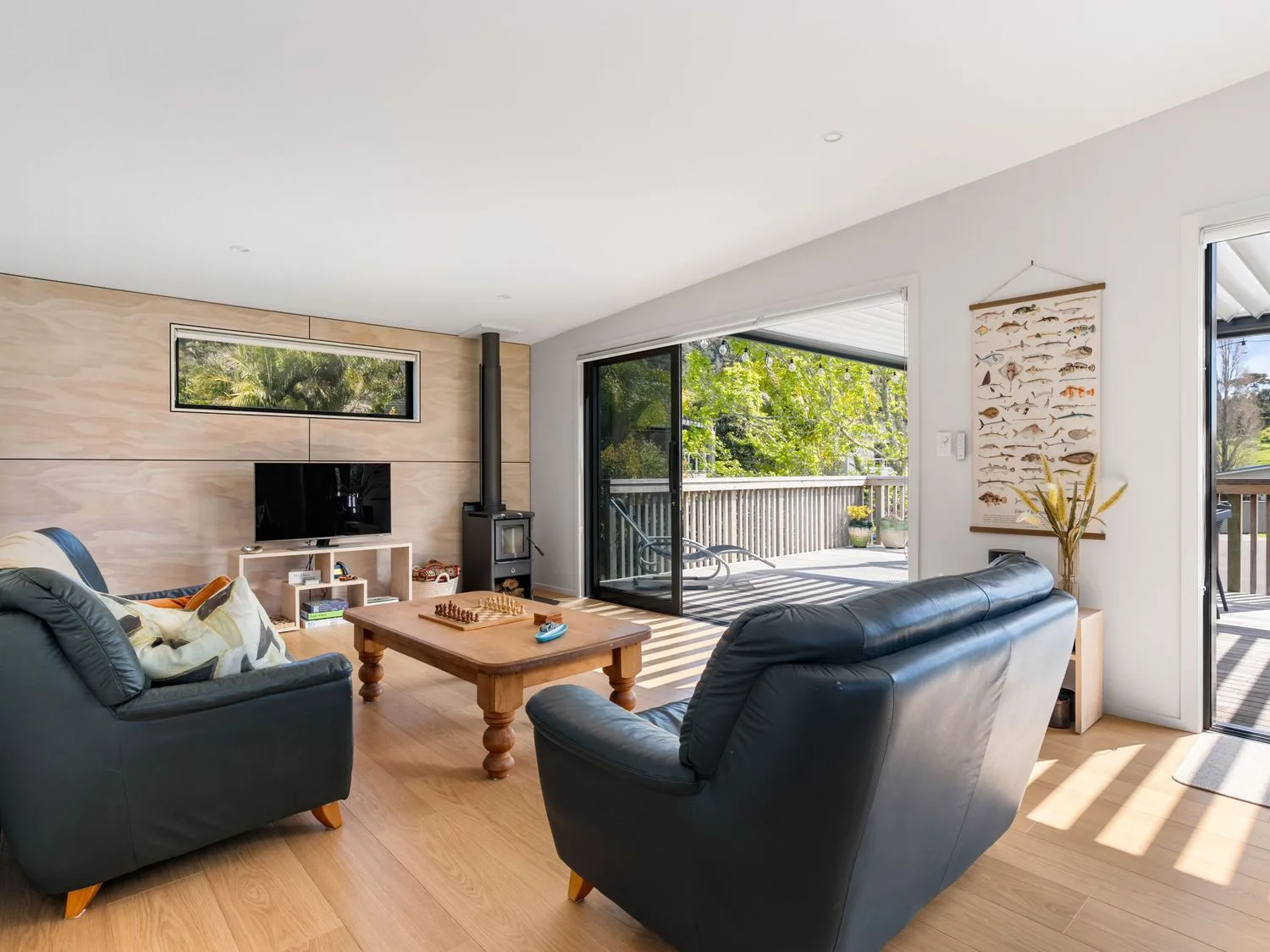 A living room with a television and a coffee table at The Cove Escape - Cooks Beach