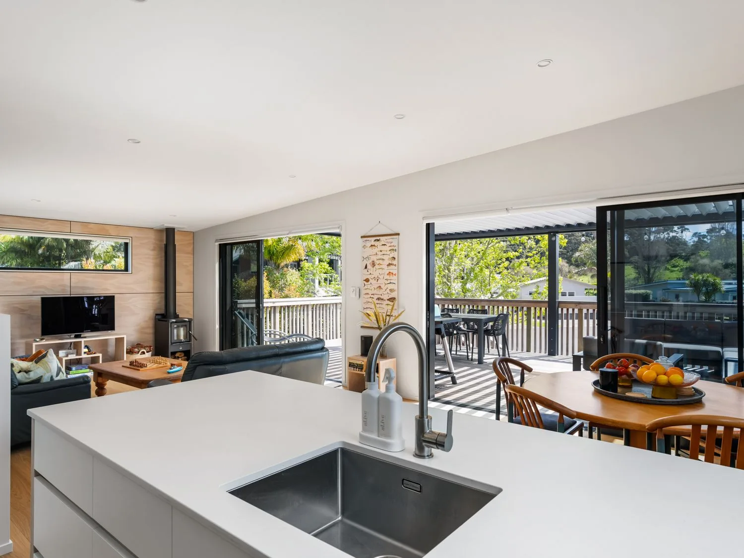 A kitchen with a sink and dining area at The Cove Escape - Cooks Beach