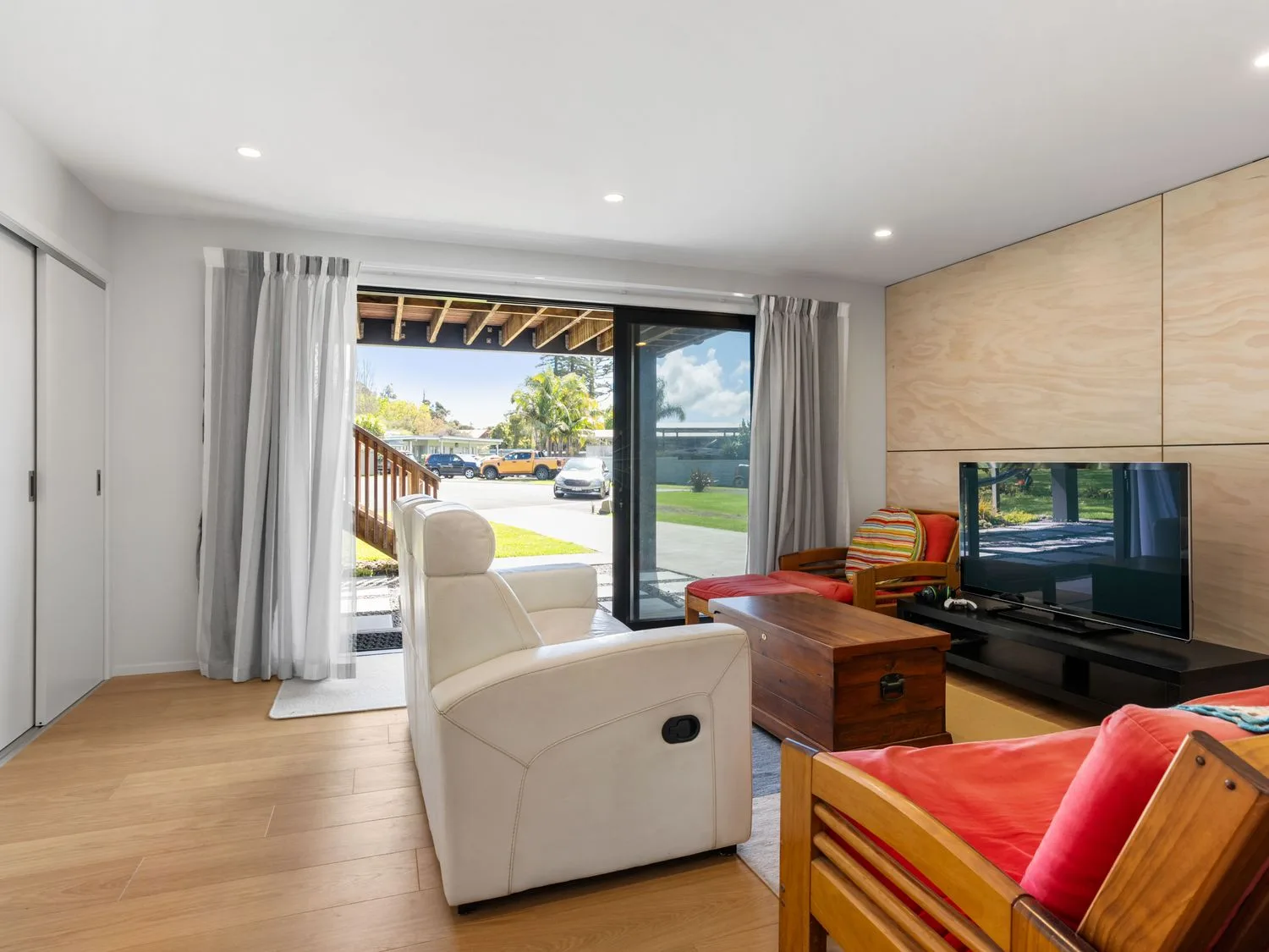 A living room with a tv and coffee table at The Cove Escape - Cooks Beach
