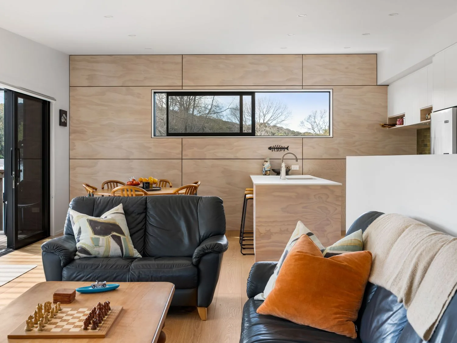 A living room with a sofa and coffee table at The Cove Escape - Cooks Beach