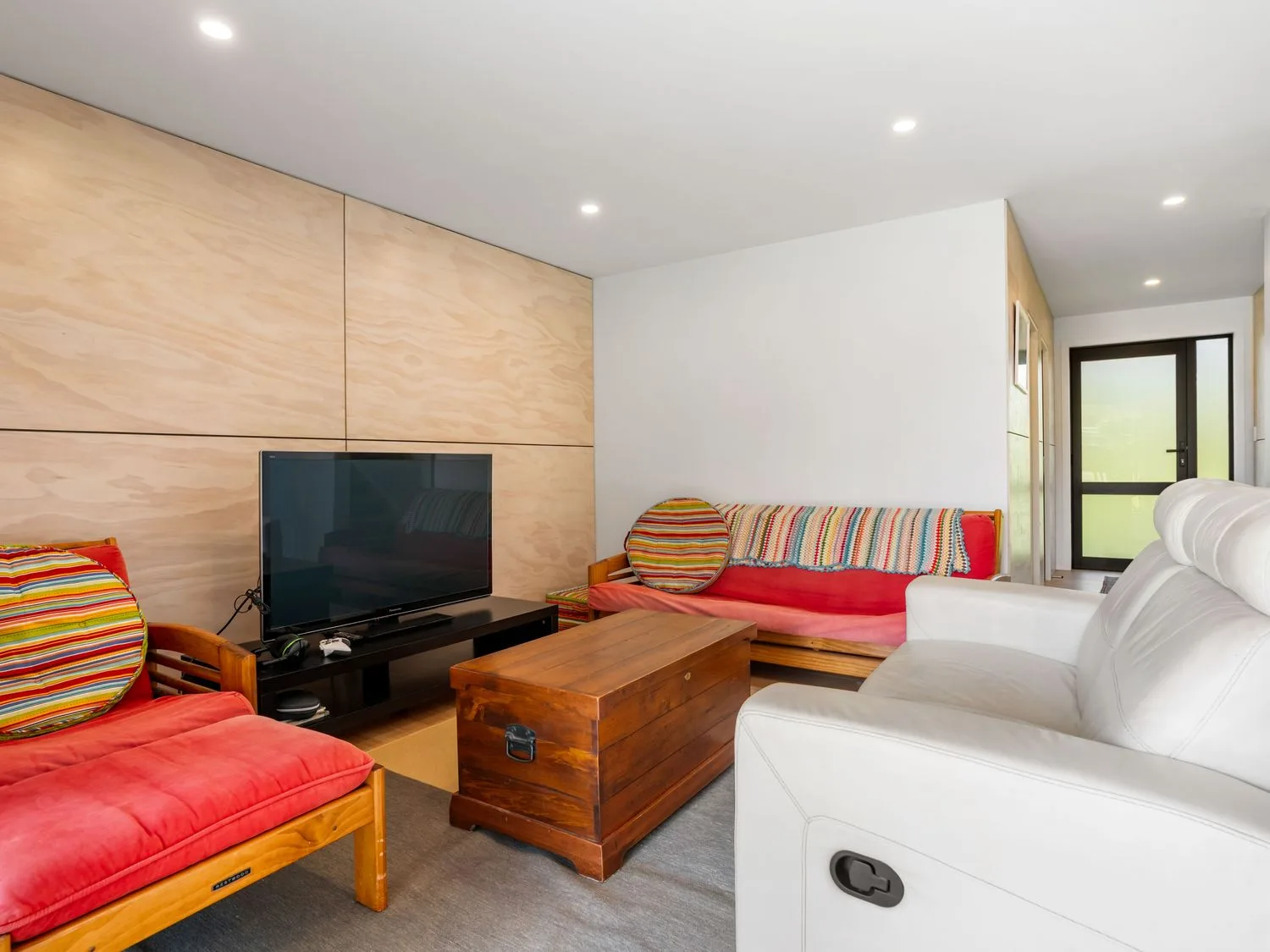 A living room with a television and sofa at The Cove Escape - Cooks Beach