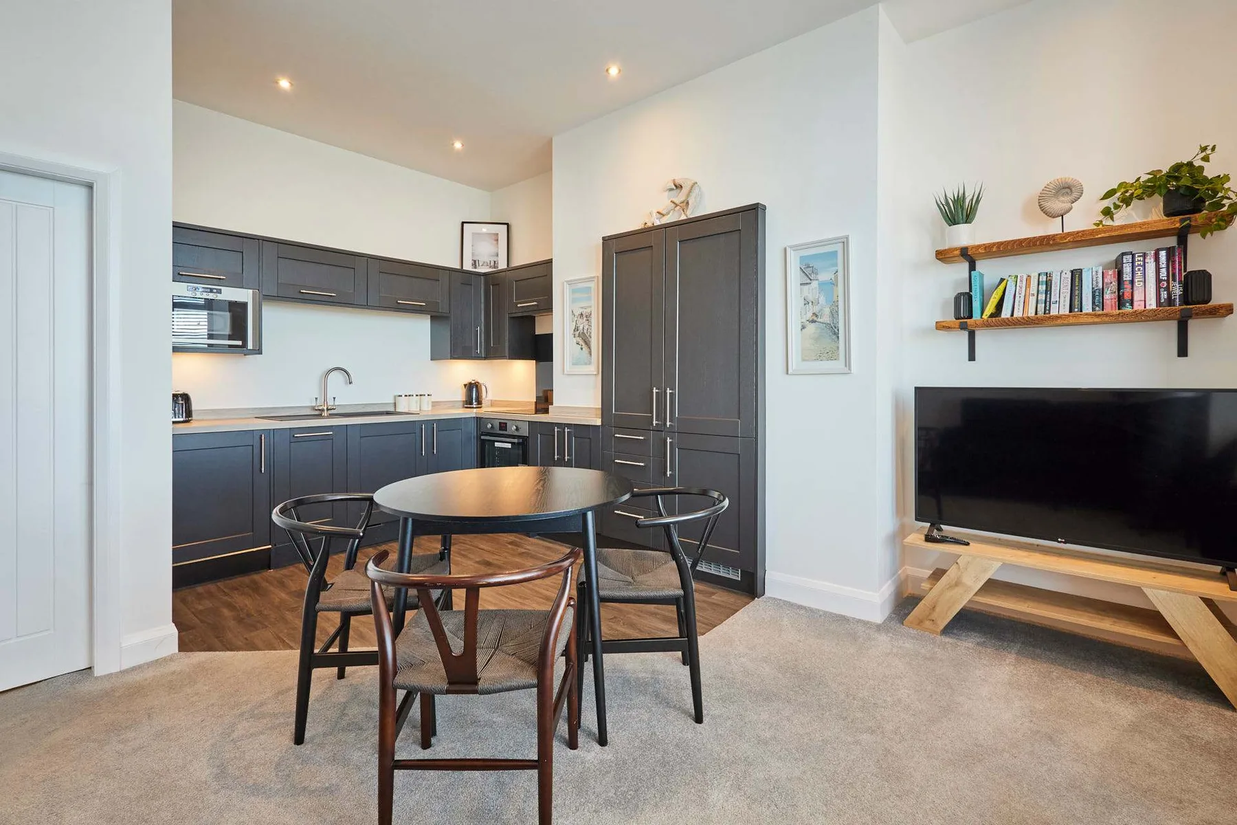 Una sala-comedor de concepto abierto con cocina y mesa redonda.