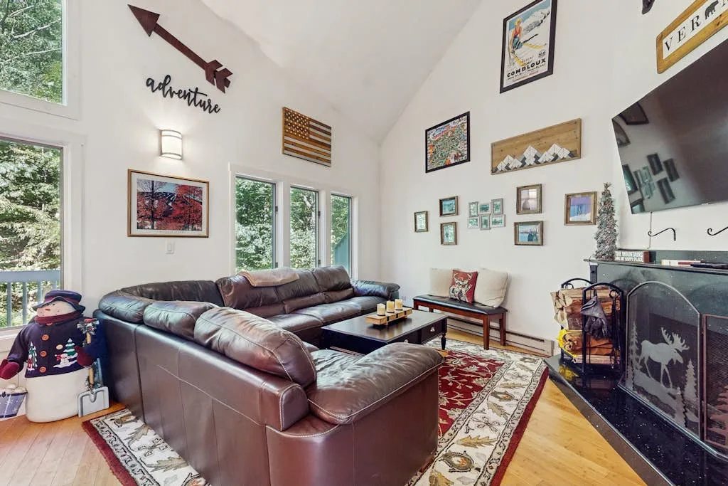 A living room with leather seating, a coffee table, and framed wall art.