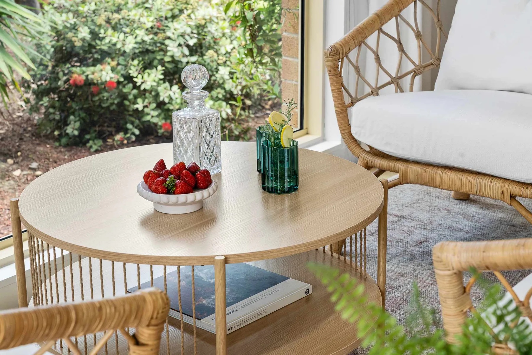 A sunlit seating area with a round table and garden views.