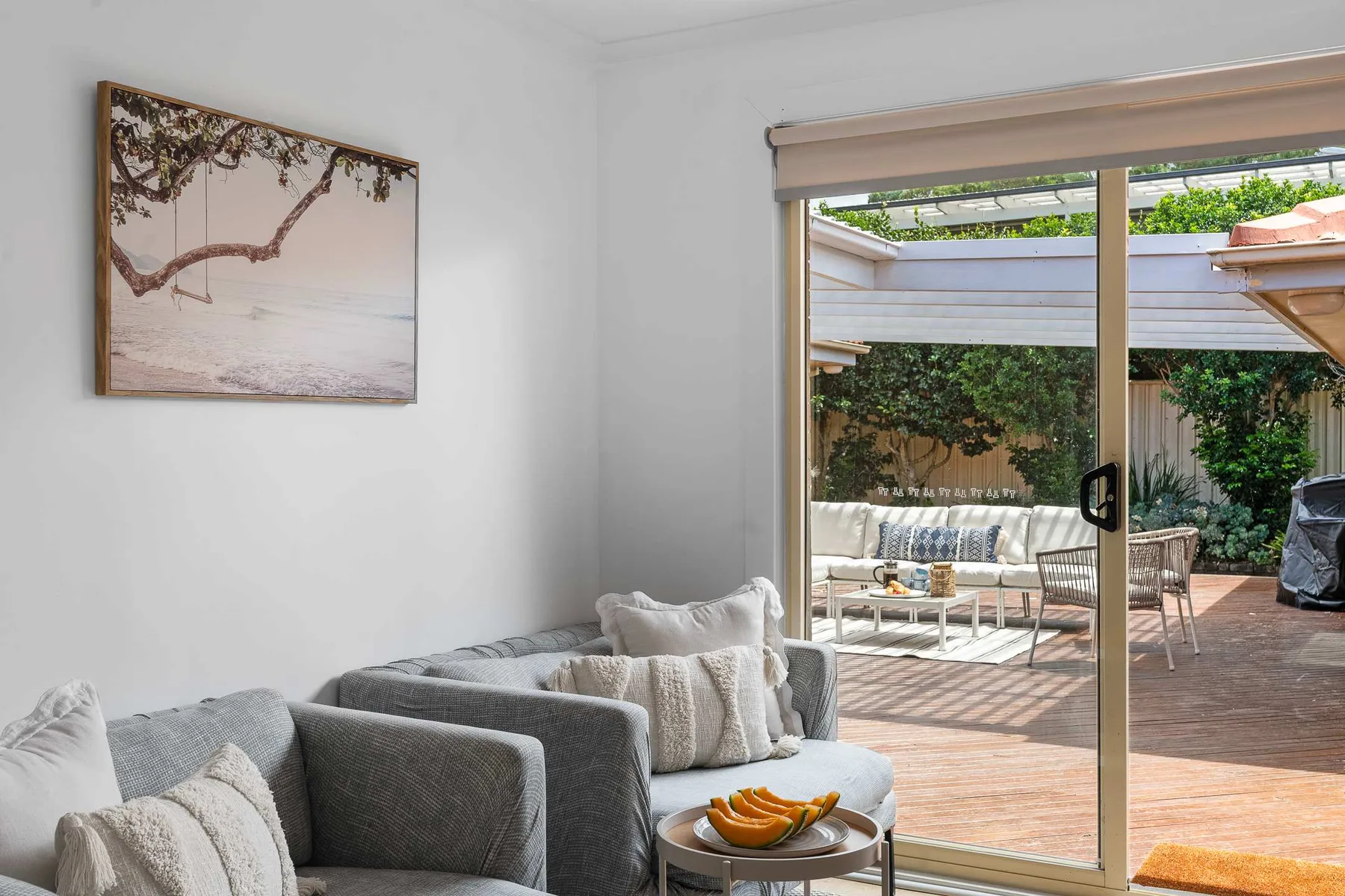 A living room with seating and a sliding glass door opening onto a patio.
