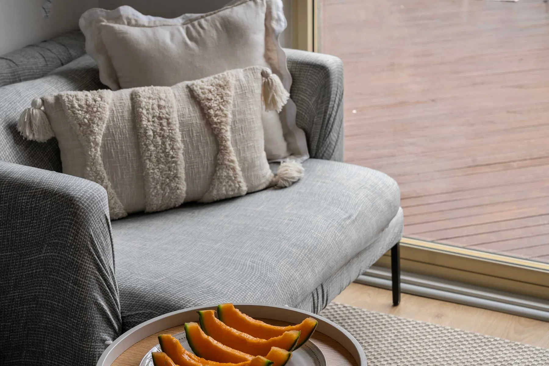 A seating area with textured cushions beside a glass door.