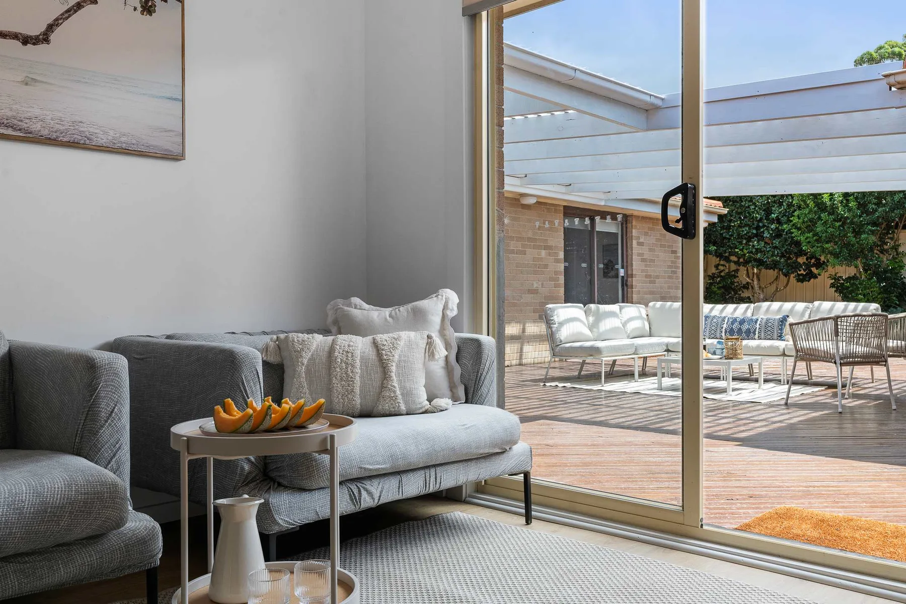 A living room opens onto a patio with outdoor seating.