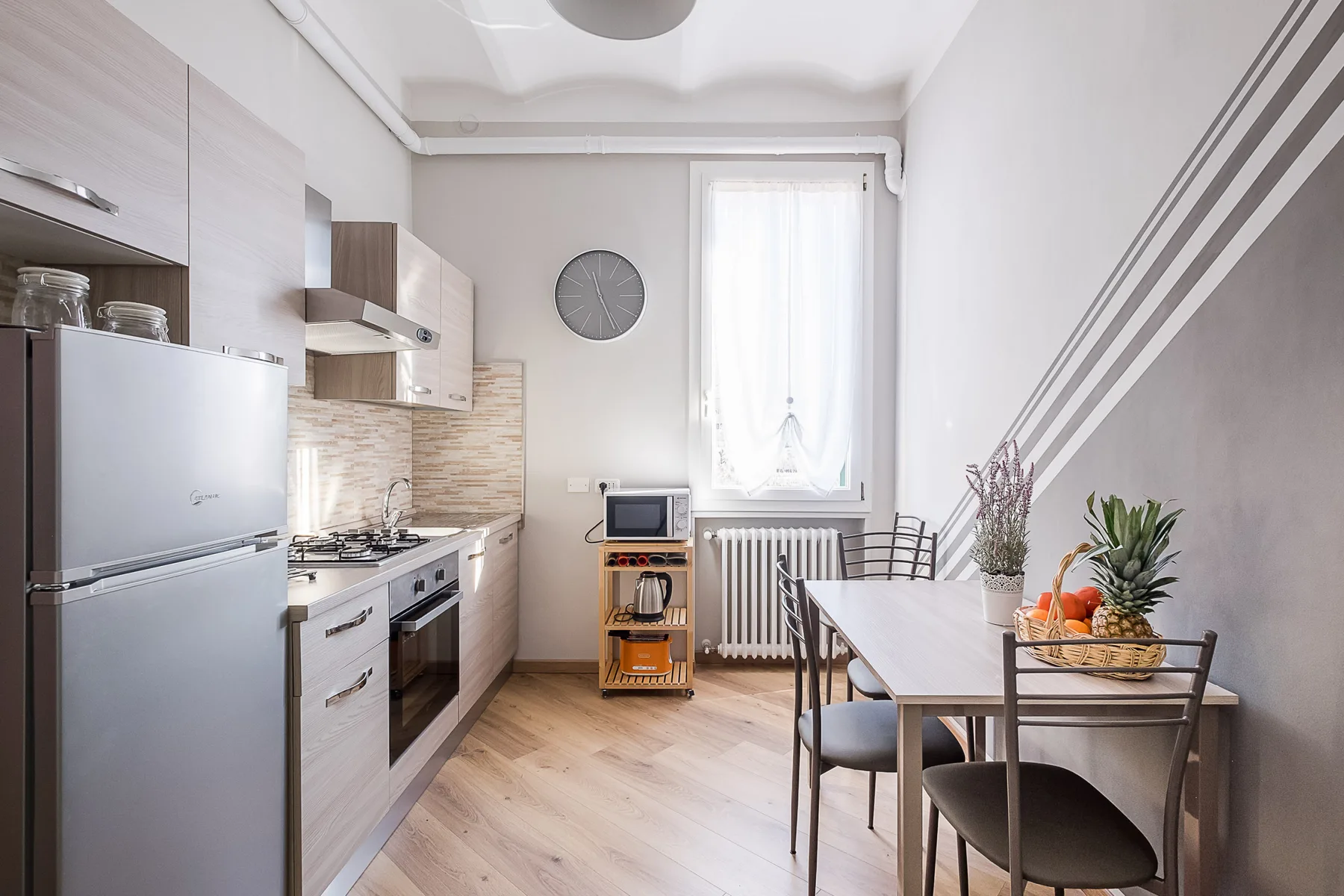 A bright kitchen and dining area with a table beside a window.