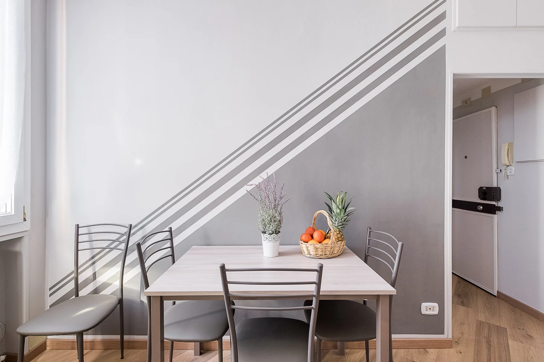 A dining area with a table and chairs beside a window.