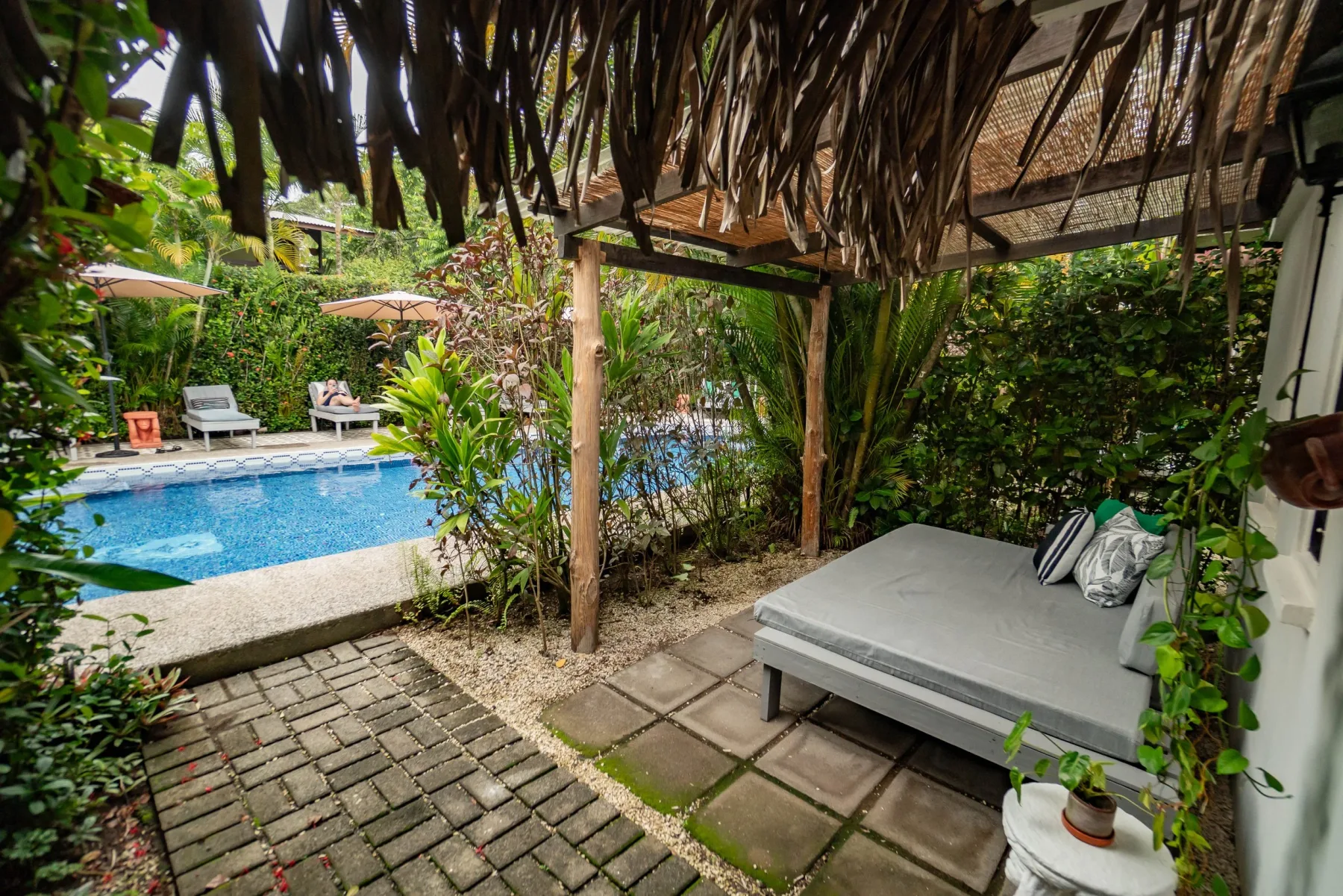 Outdoor pool area with loungers and a shaded seating area.