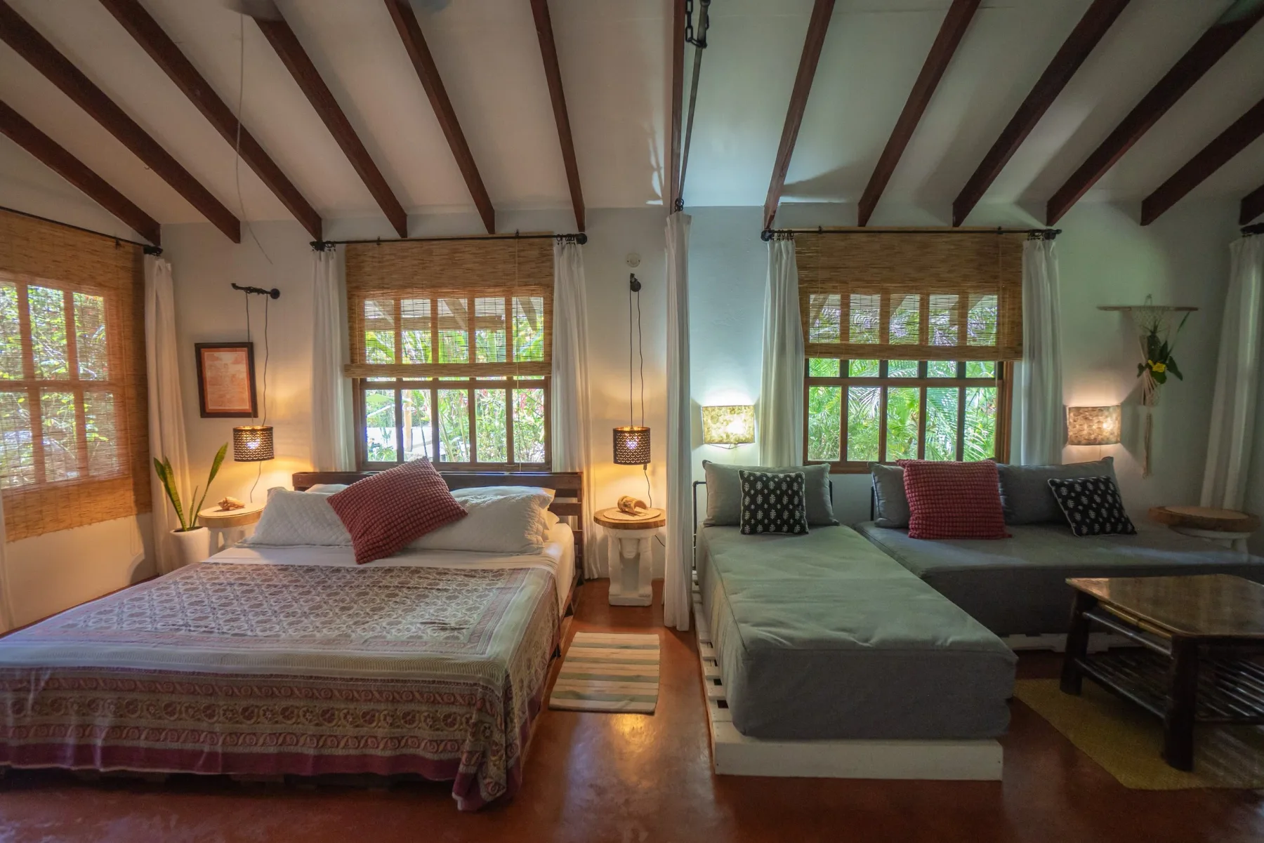 Bedroom with two beds and windows with bamboo shades.