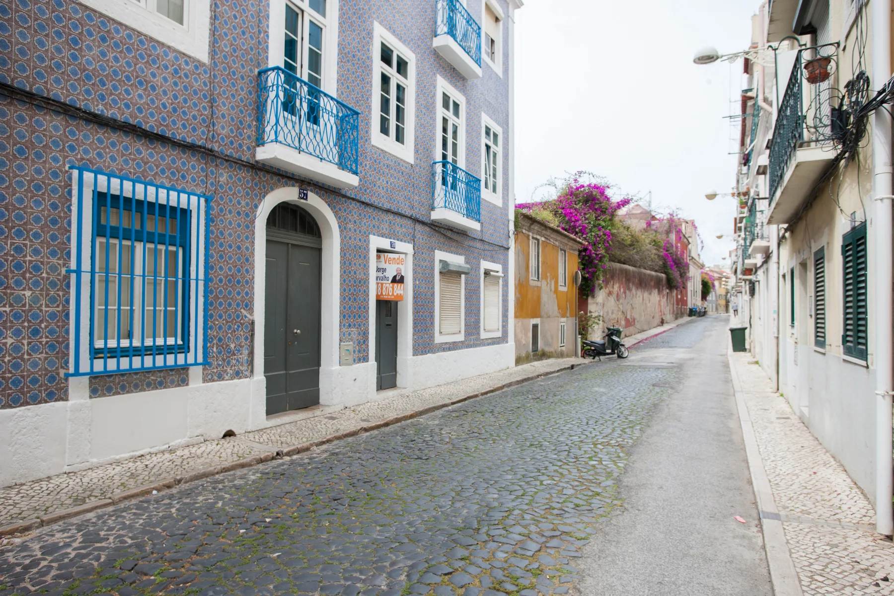 Una calle estrecha de adoquines pasa entre edificios coloridos.