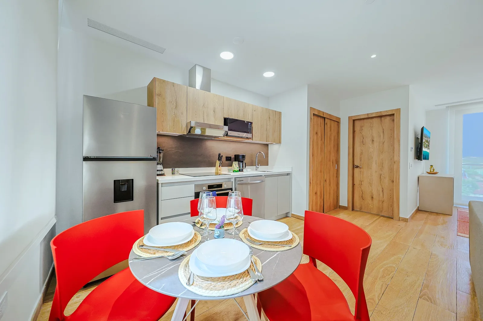 Gather around your dining table to share meals in this bright, modern space. The sleek kitchen awaits your culinary adventures, while warm wood tones add a welcoming touch to your stay.