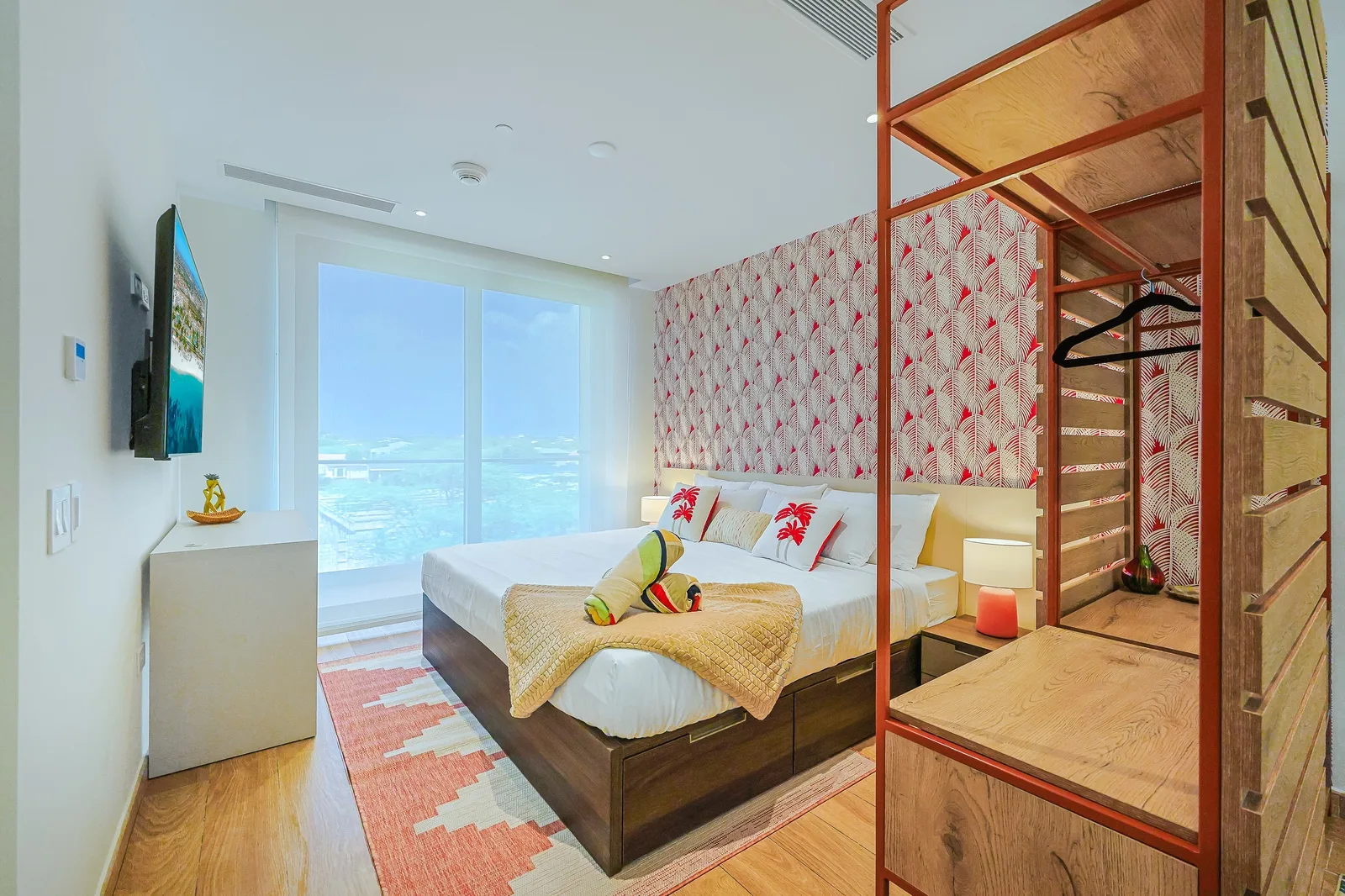 Wake up in a bright and inviting bedroom featuring floor-to-ceiling windows that fill the space with natural light. Sink into the comfortable bed surrounded by modern décor and tropical accents, creating a relaxing retreat after a day of exploring Ar
