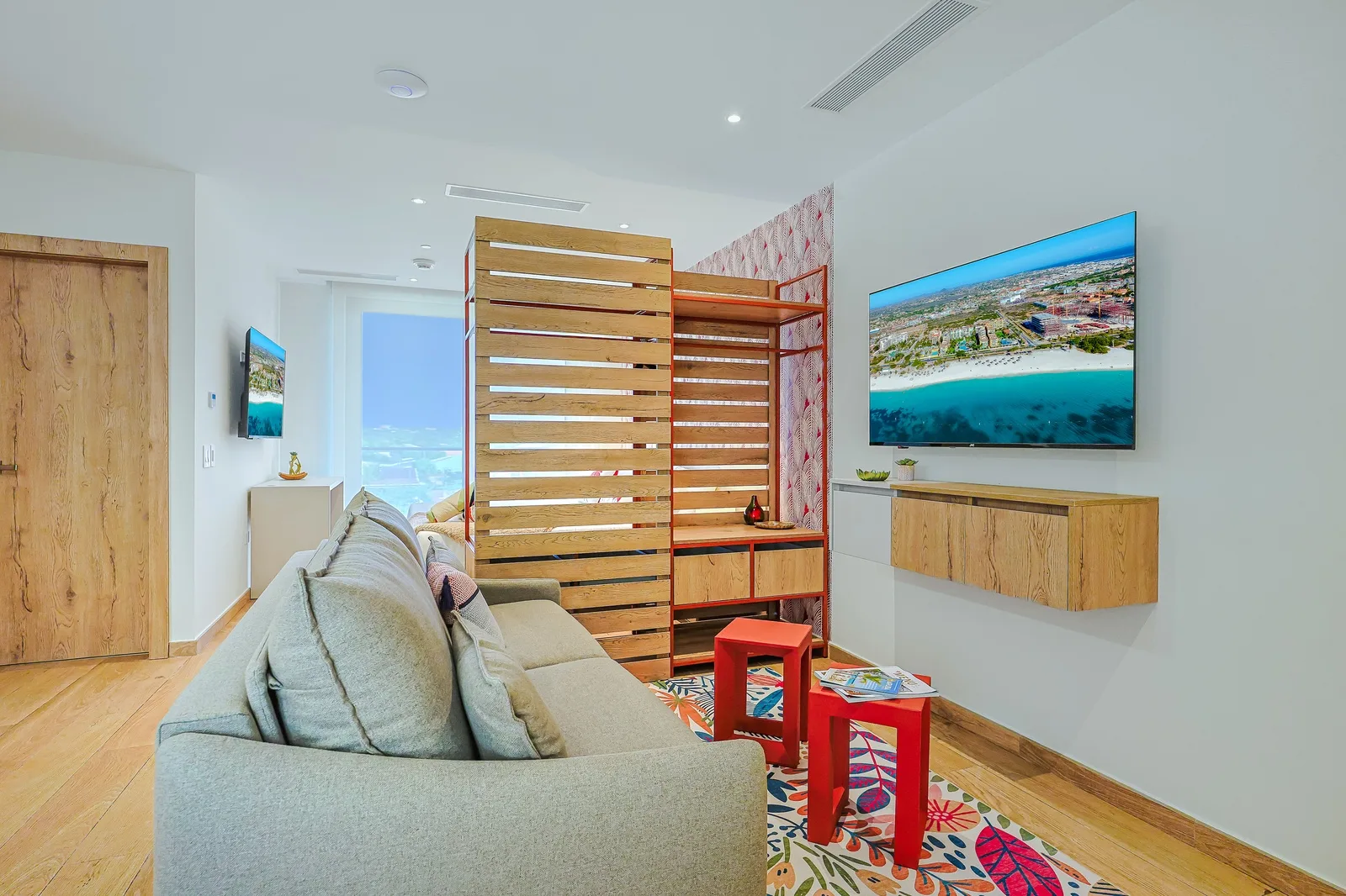 Relax in this bright living space with a plush sofa and wooden room divider. Your family will love the cheerful design and modern wood accents perfect for unwinding together.