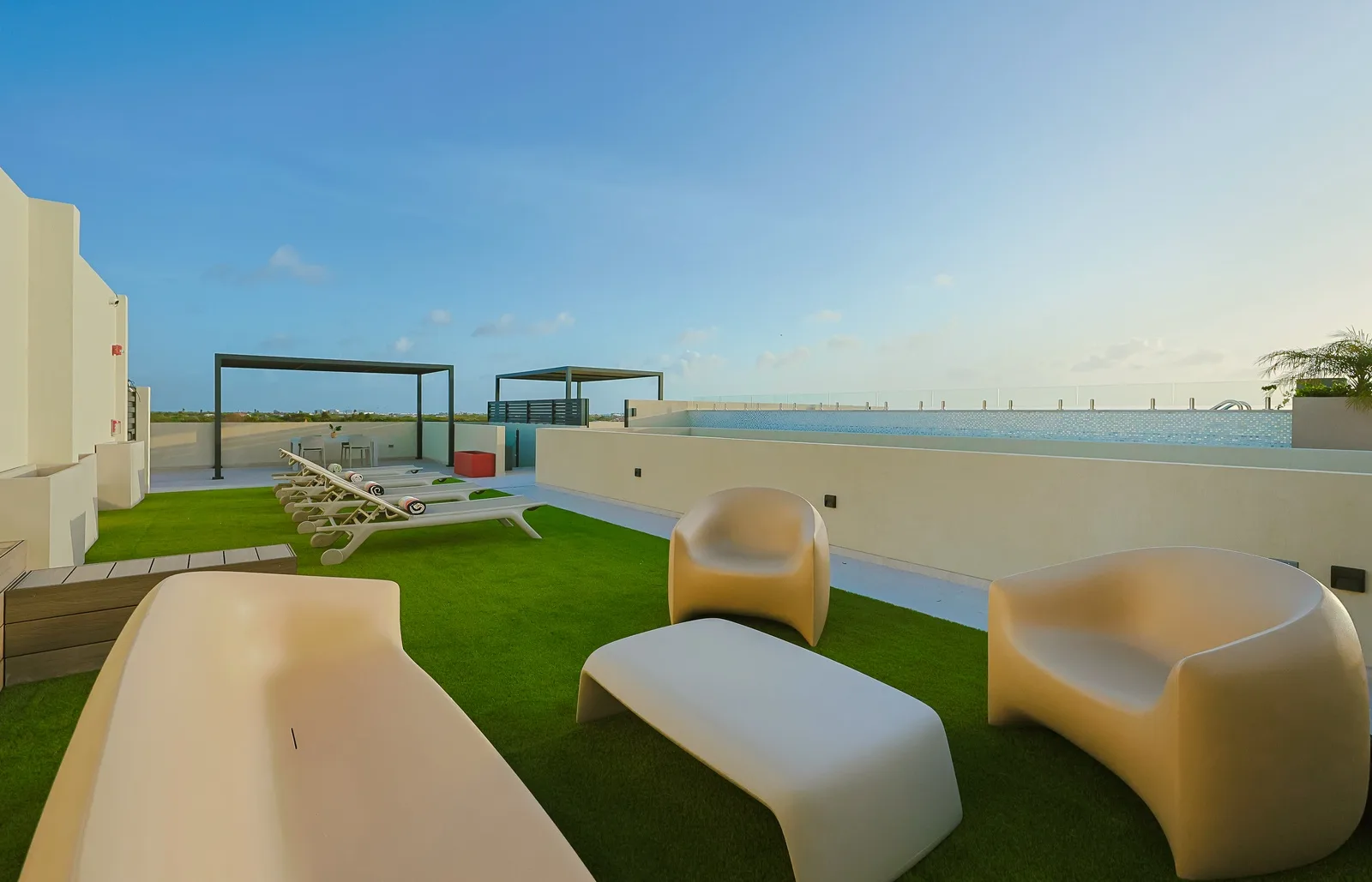 A modern rooftop terrace with sculptural loungers invites you to relax under the warm Aruba sunshine and enjoy a peaceful outdoor escape.