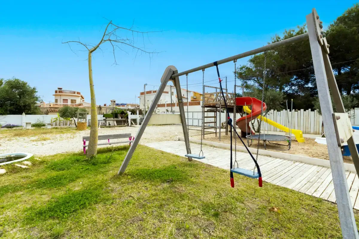 Un parque infantil al aire libre con una estructura para trepar y un tobogán de colores.