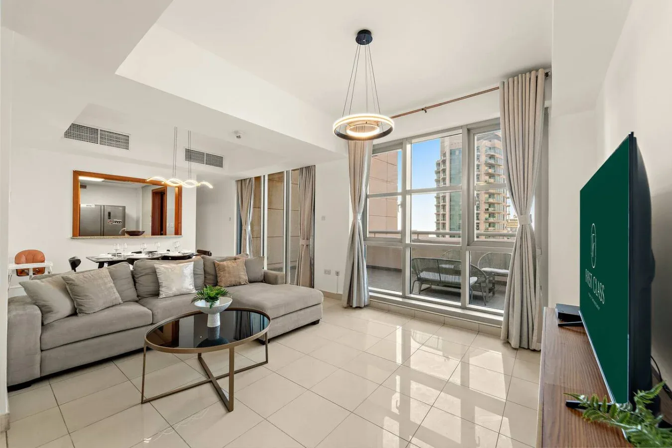 Una sala luminosa con asientos junto a grandes ventanas y una mesa de centro de vidrio.