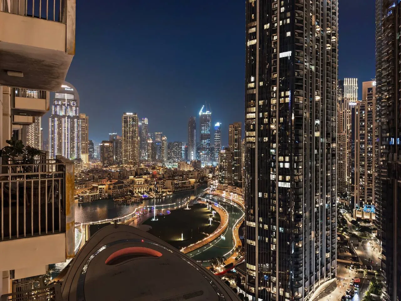 Un horizonte urbano nocturno con edificios iluminados y una orilla curva.