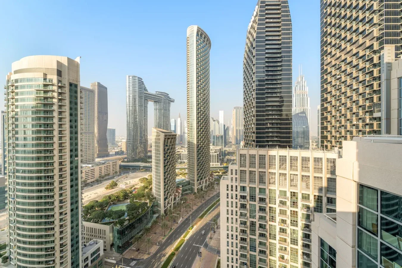 Horizonte urbano con edificios altos modernos junto a una amplia avenida.