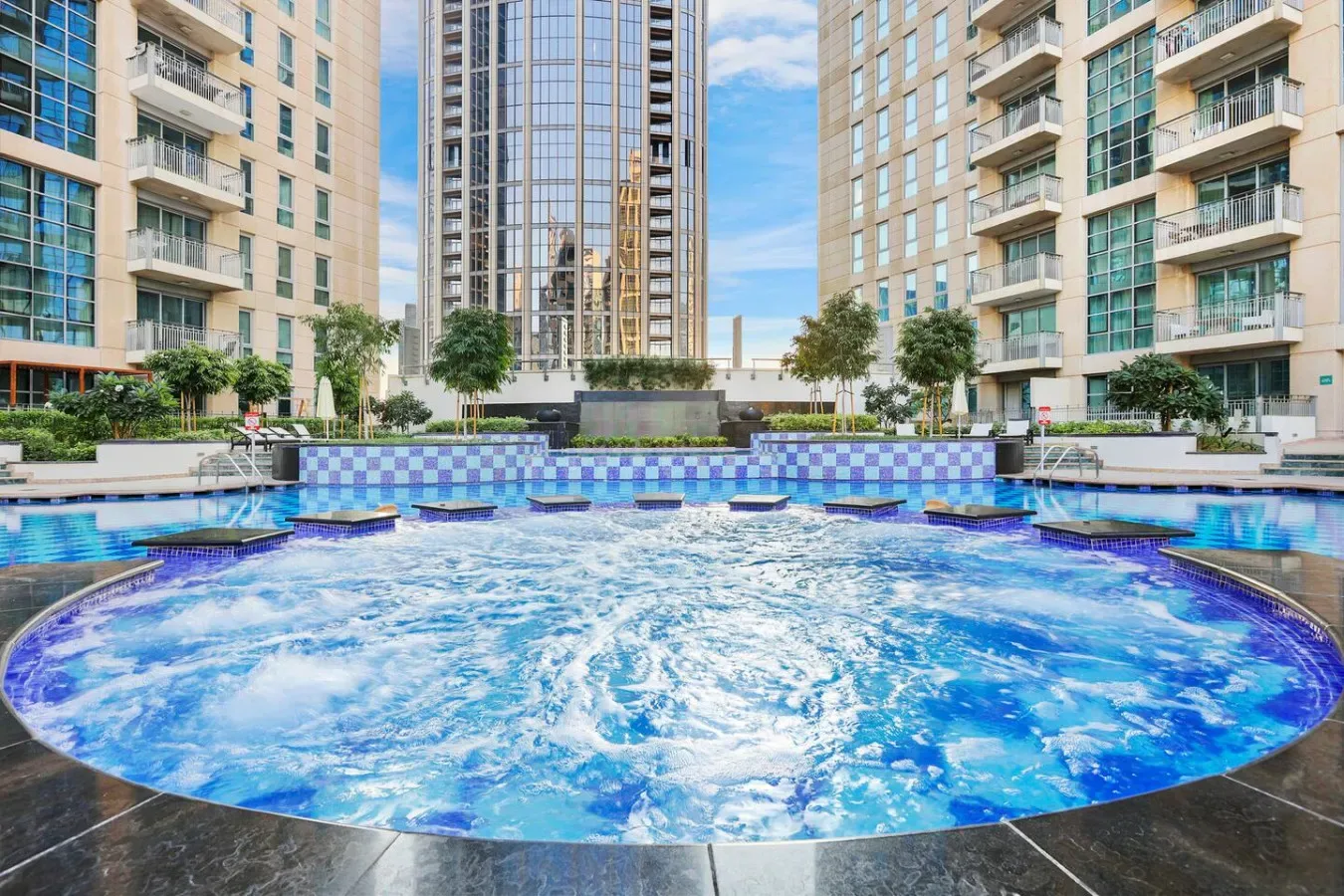Una gran piscina al aire libre está entre edificios residenciales altos.