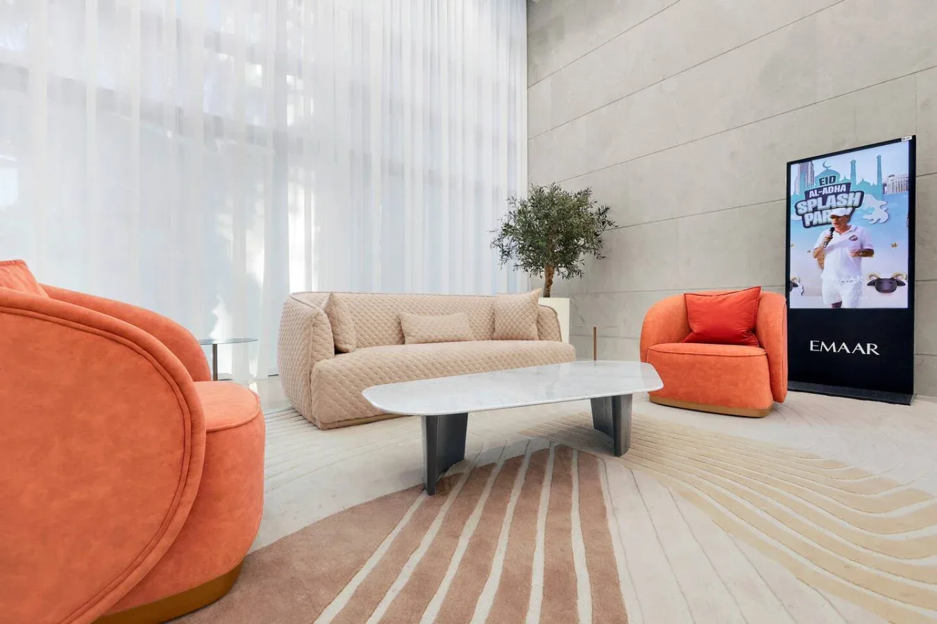 Una luminosa zona de estar con mesa de centro y grandes ventanas con cortinas translúcidas.