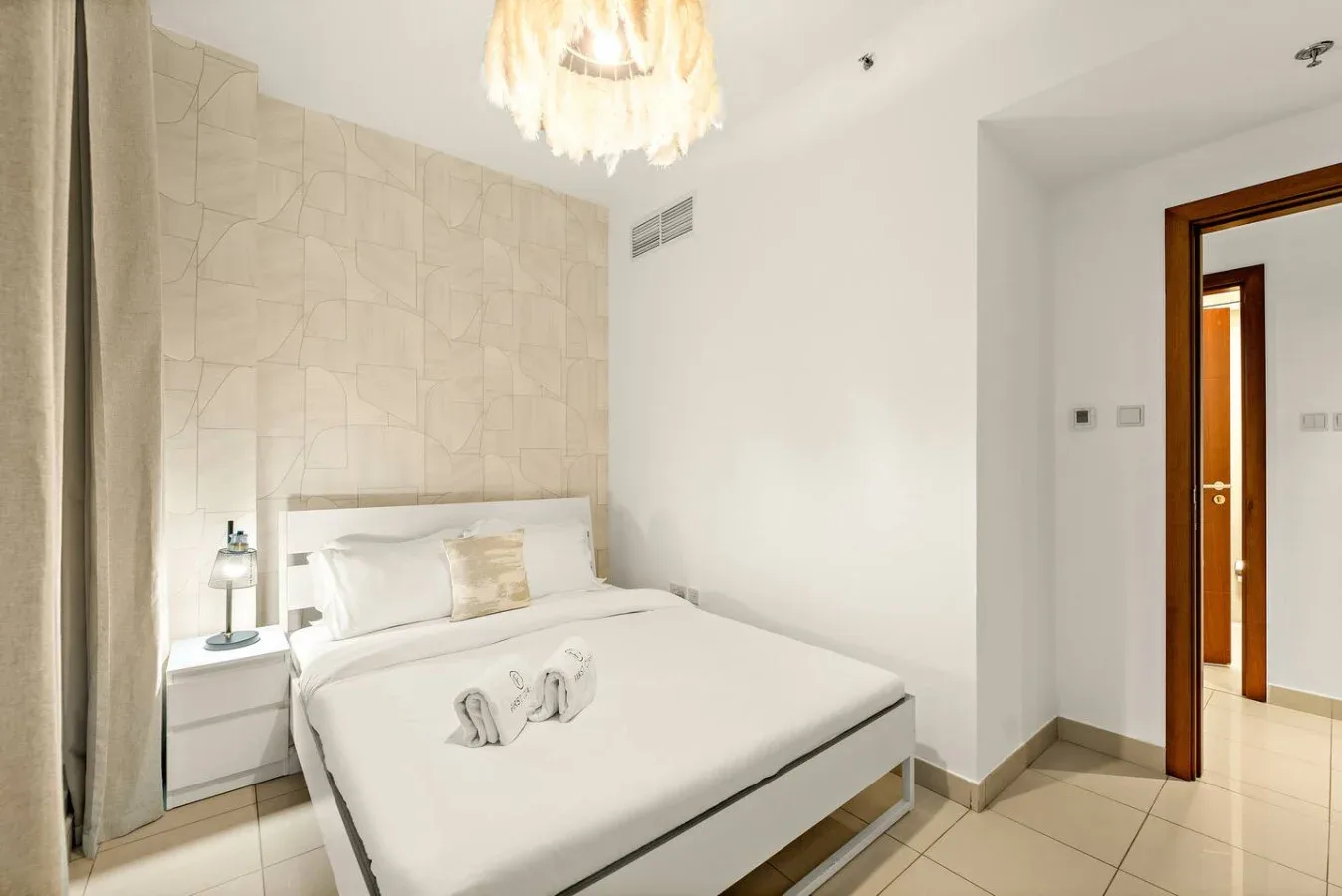 Un dormitorio con una cama tendida y una mesita de noche.