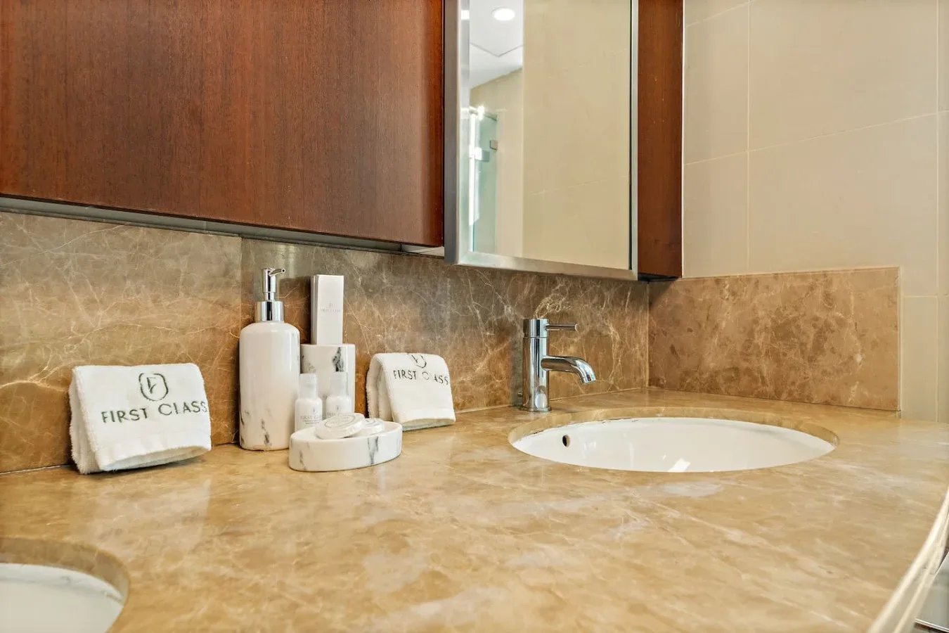 Un tocador de baño con lavabo, espejo y artículos de aseo sobre la encimera.
