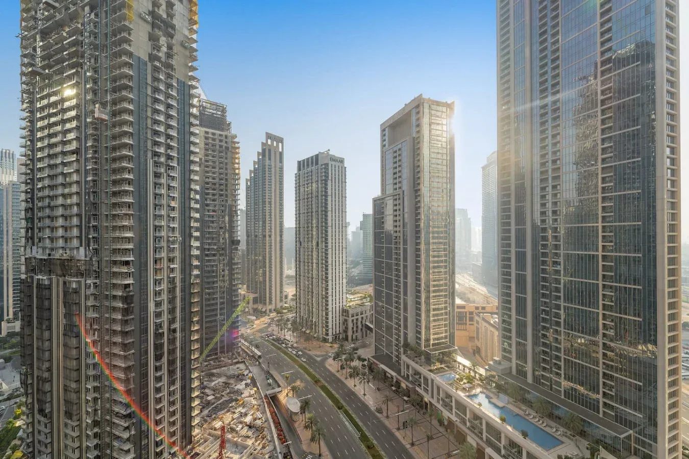Un horizonte urbano de edificios altos rodea una carretera curva bajo un cielo despejado.