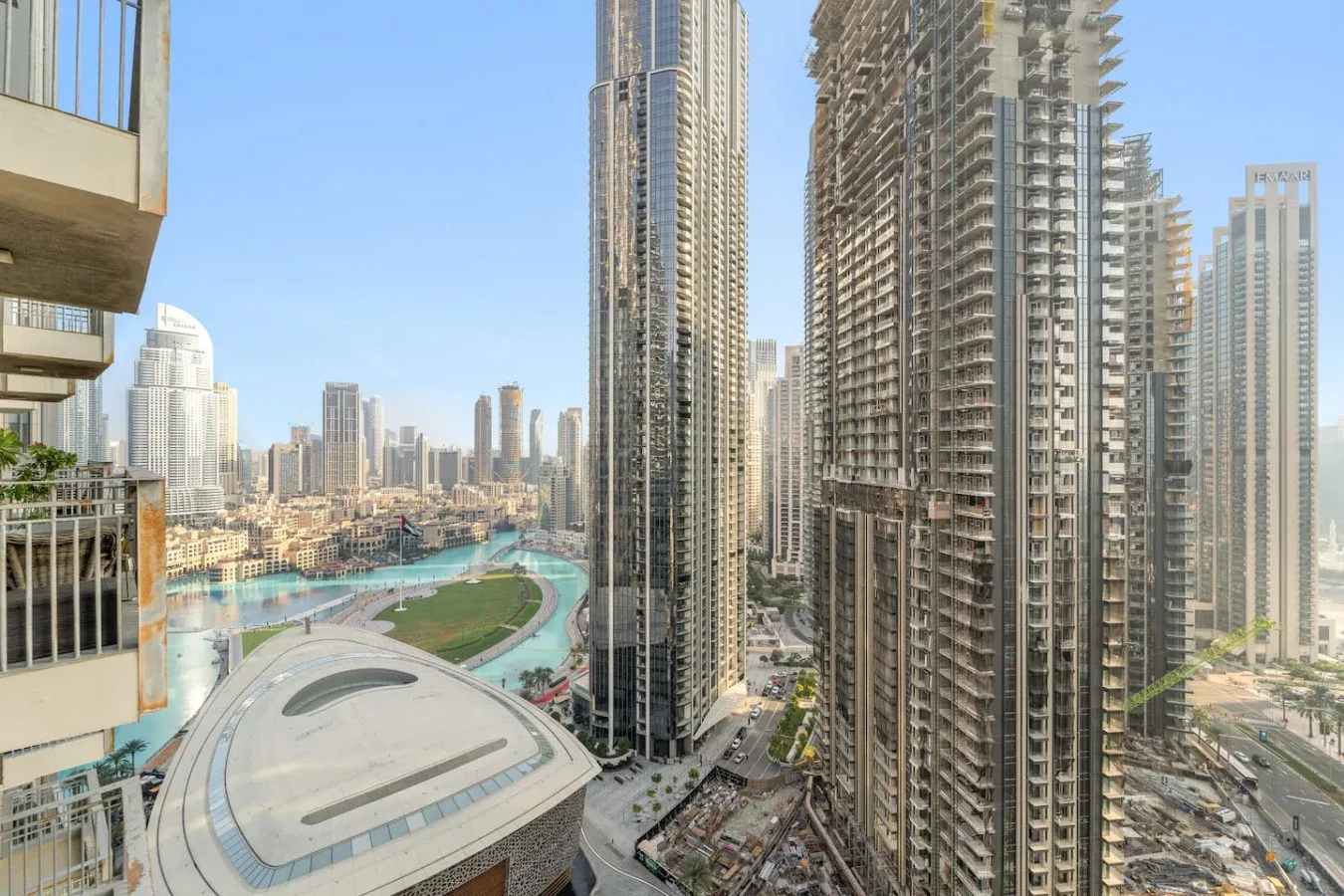 Un horizonte urbano con torres altas domina un edificio curvo y zonas ajardinadas.
