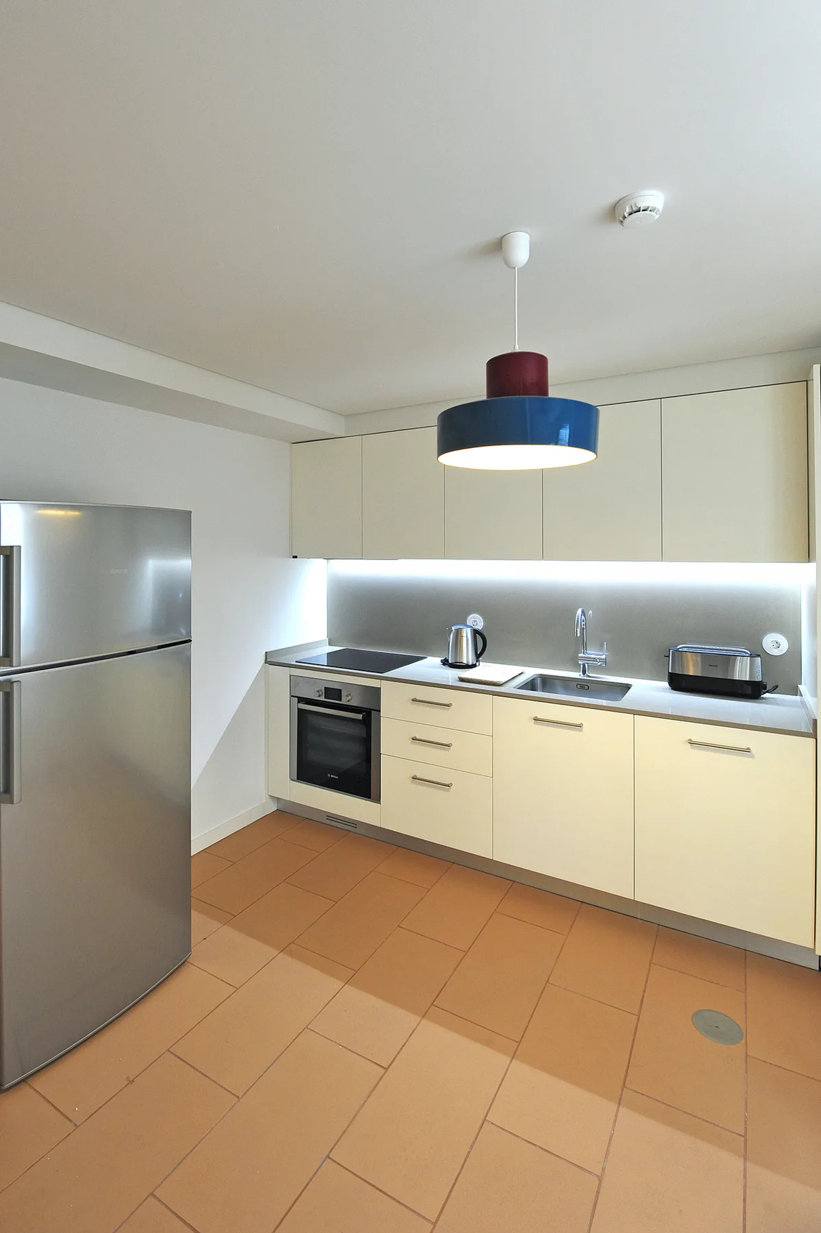 A modern kitchen with light cabinets, a countertop, and stainless steel appliances.
