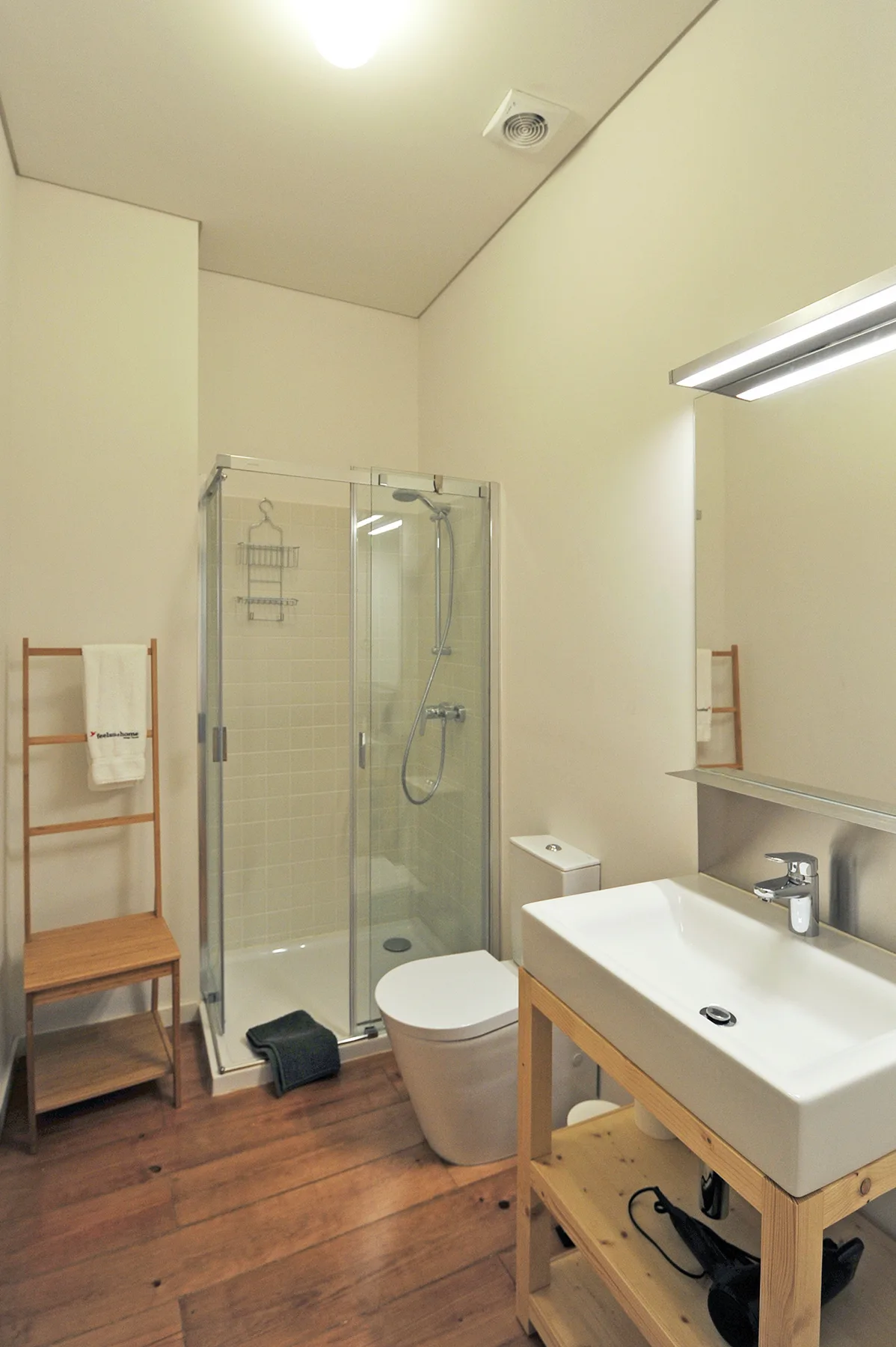 A bathroom with a glass shower, toilet, and sink.