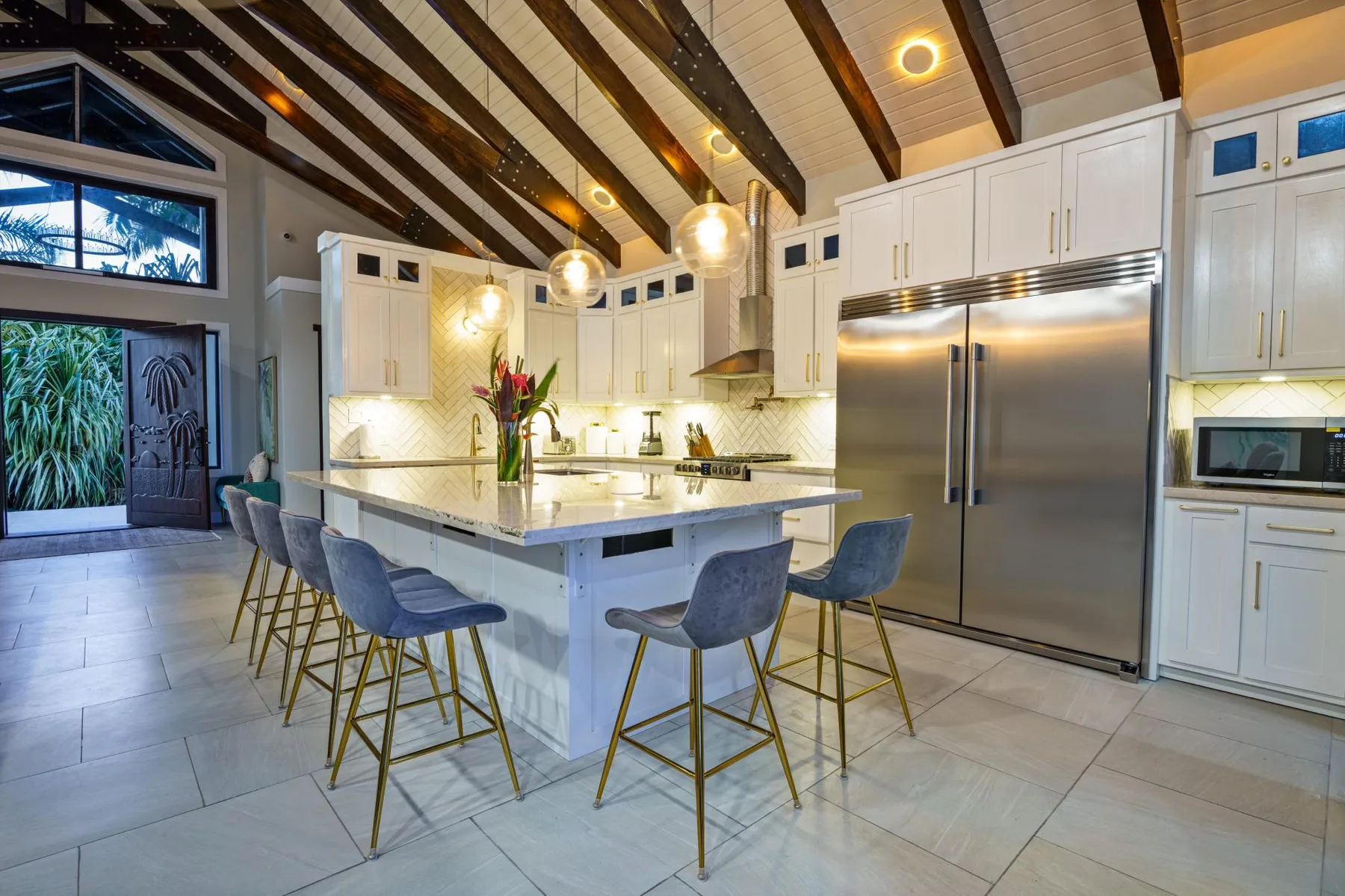 A spacious kitchen with a central island, bar seating, and stainless steel appliances.