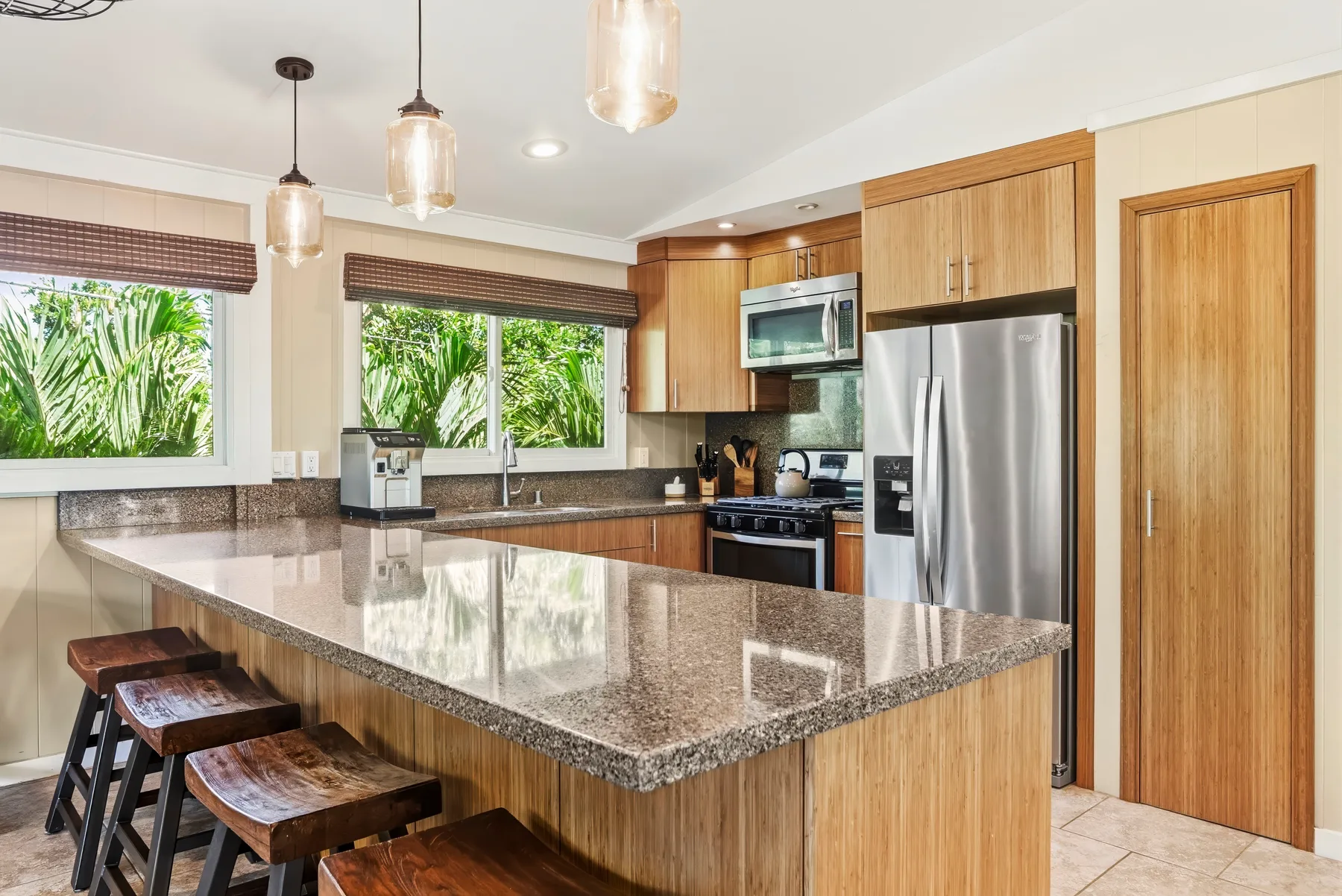 Una cocina luminosa con gabinetes de madera, electrodomésticos de acero inoxidable y una isla grande.