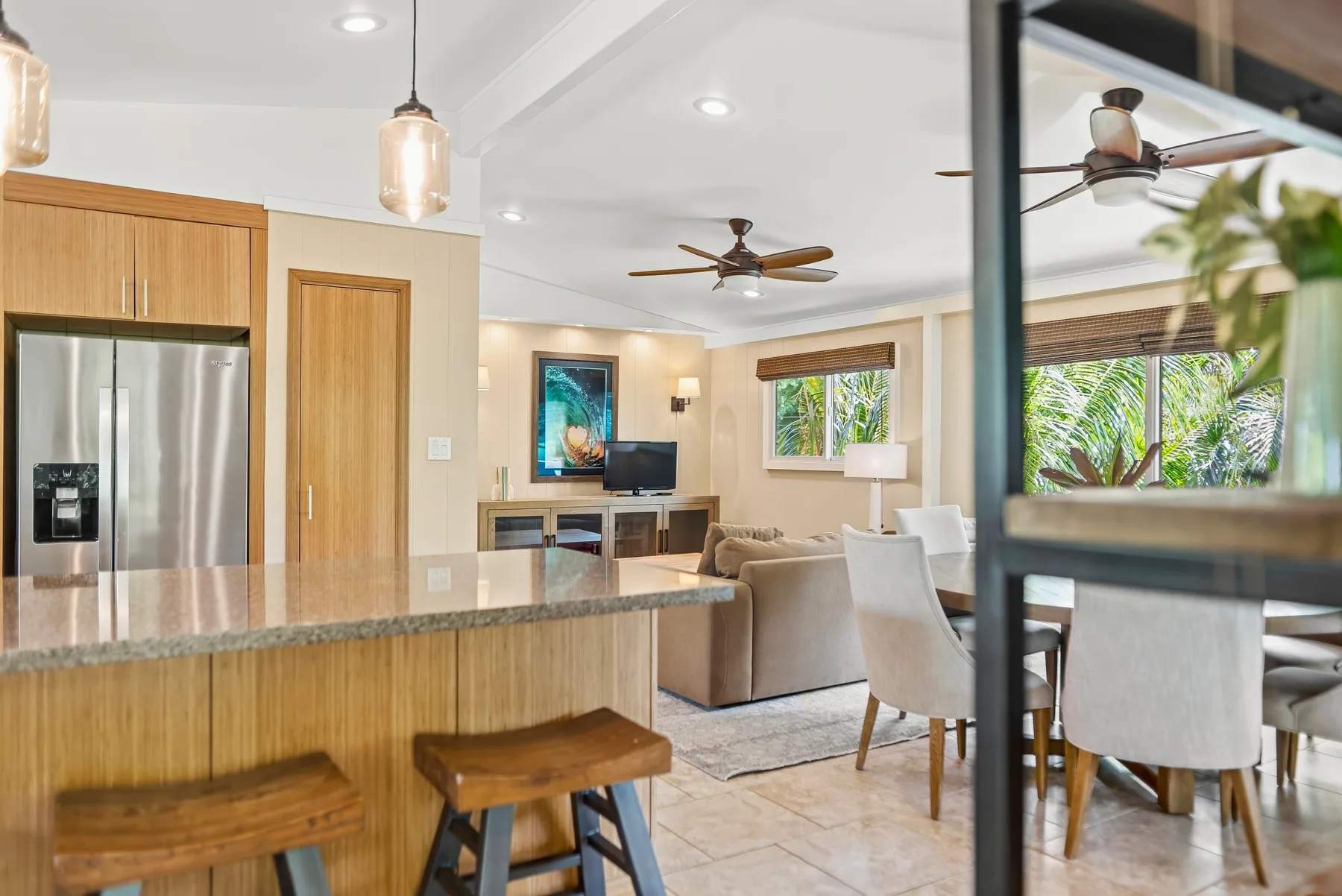 Una cocina abierta y sala de estar con una mesa de comedor junto a las ventanas.