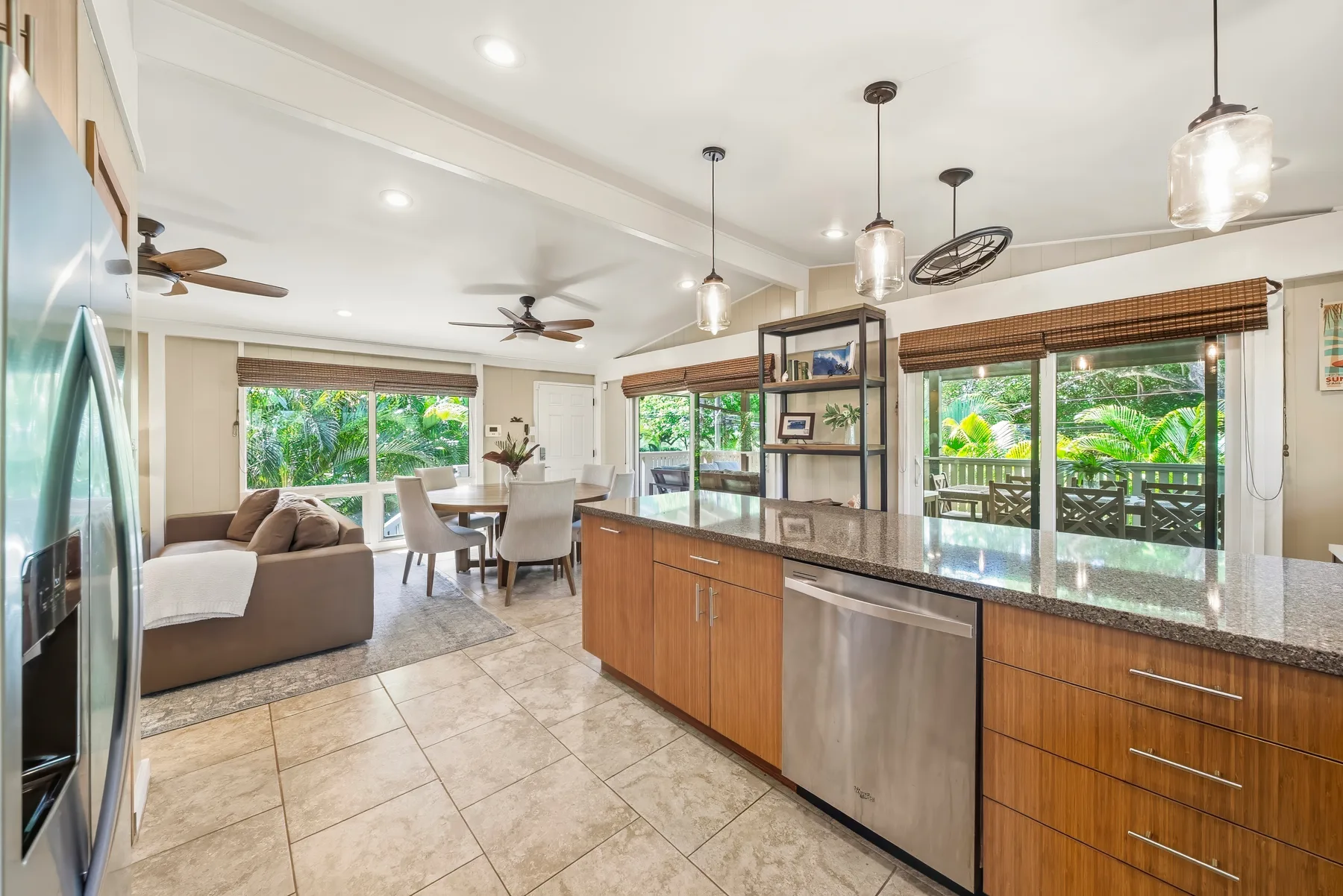 Cocina y comedor abiertos, con una zona de estar junto a amplias ventanas.