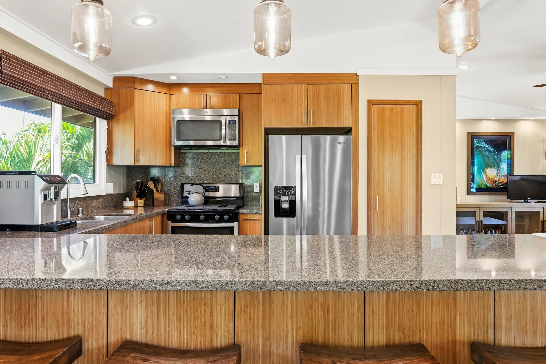 Una cocina luminosa con gabinetes de madera, electrodomésticos de acero inoxidable y una amplia encimera.