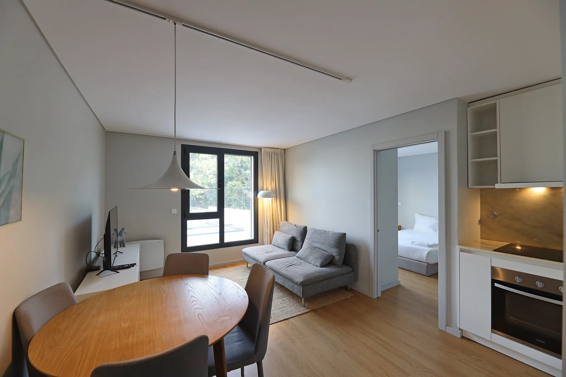 Living room with dining table, seating, and a large window.