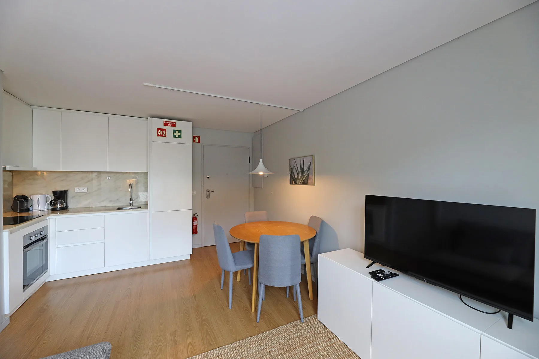 An open-plan kitchen and dining area with a television beside the table.