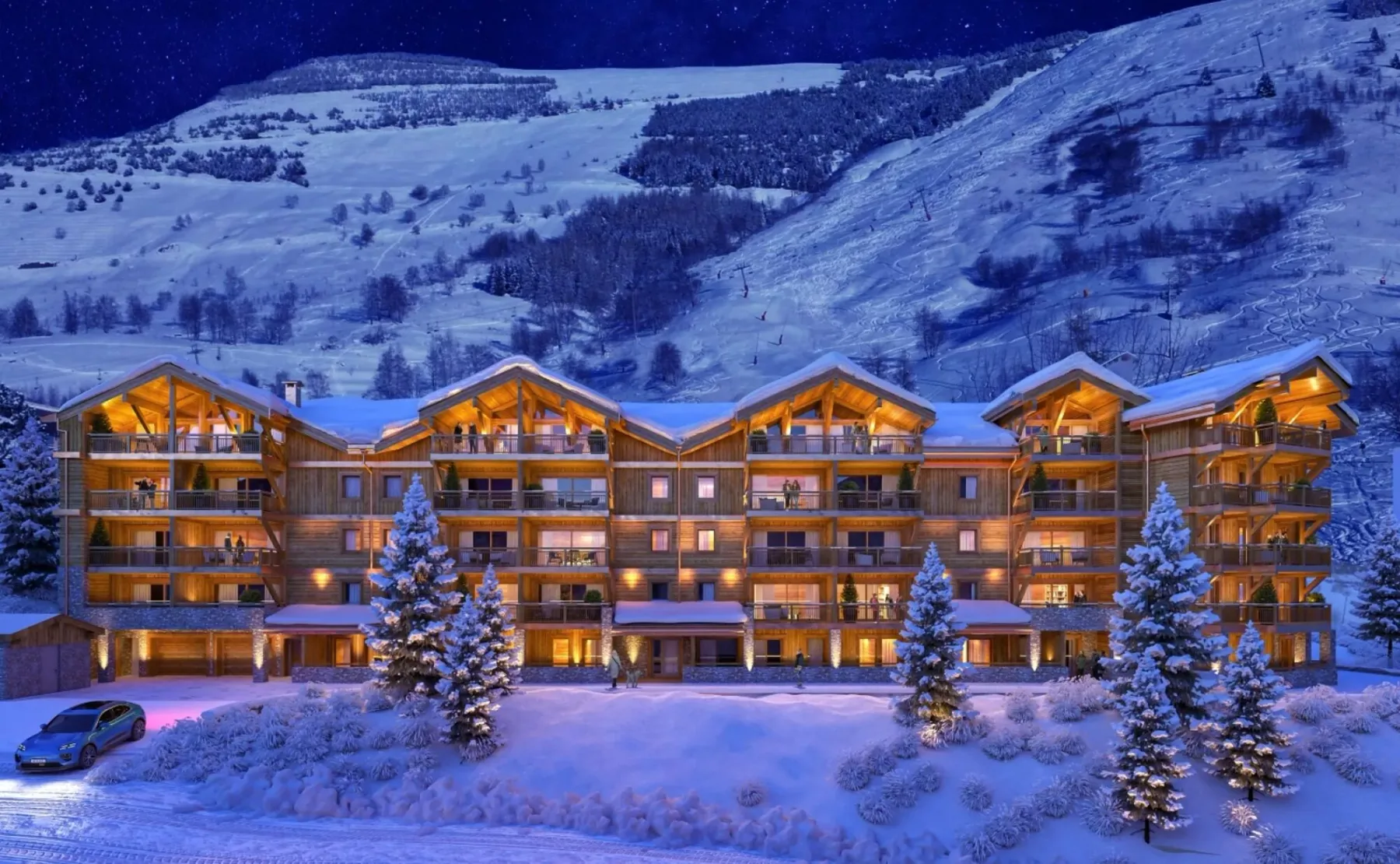 Una hilera de edificios de apartamentos iluminados se alza frente a una montaña nevada al anochecer.