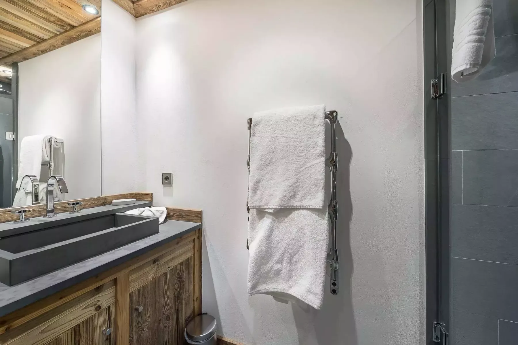 Un lavabo de baño está junto a un toallero y una ducha.