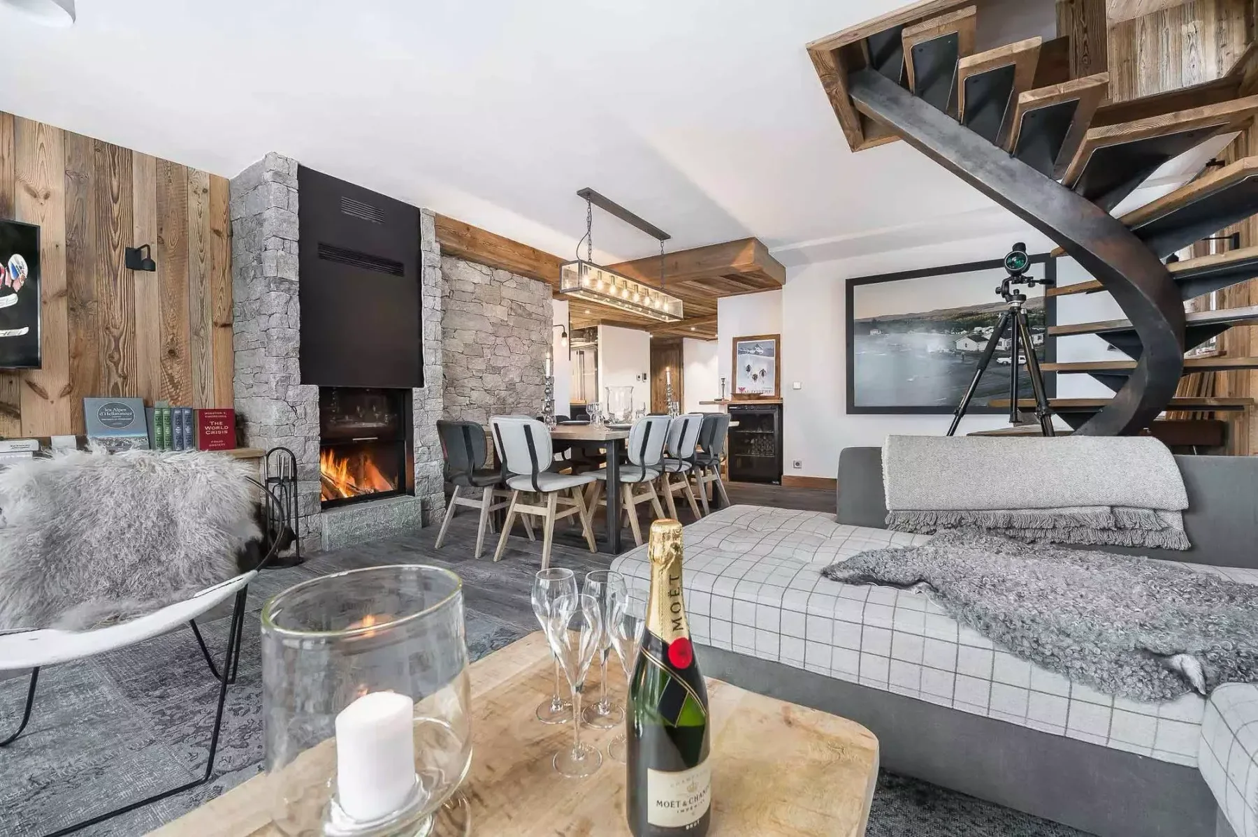 A living and dining area features a dining table, fireplace, and staircase.