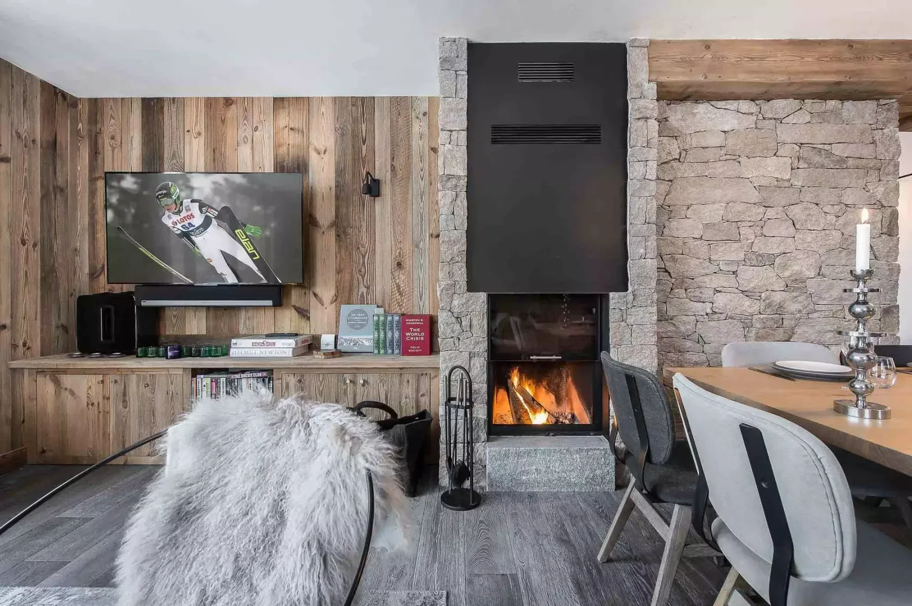 A dining and living area with a television, fireplace, and table.