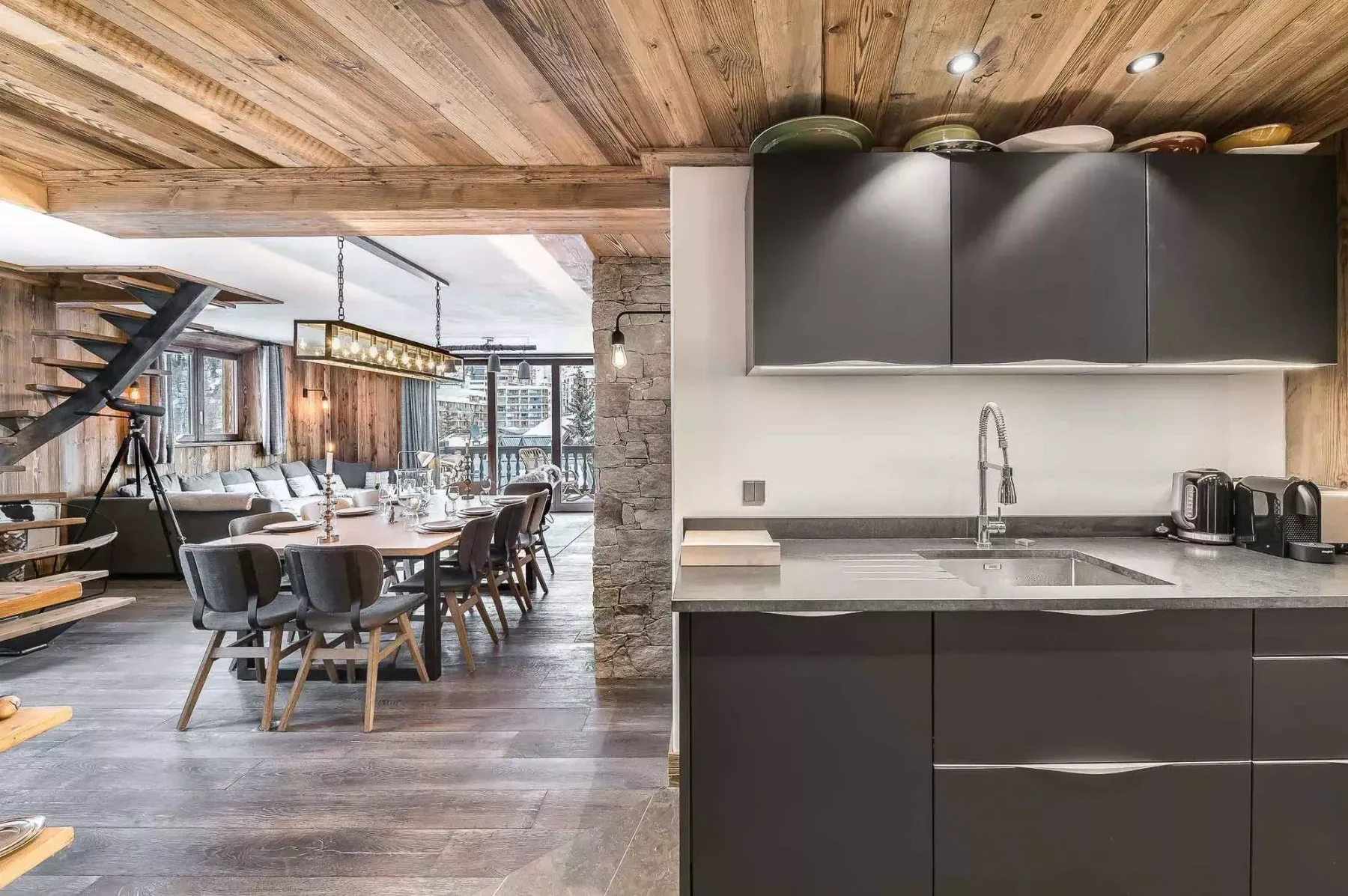 An open-plan kitchen and dining area with a long dining table beside the counter.